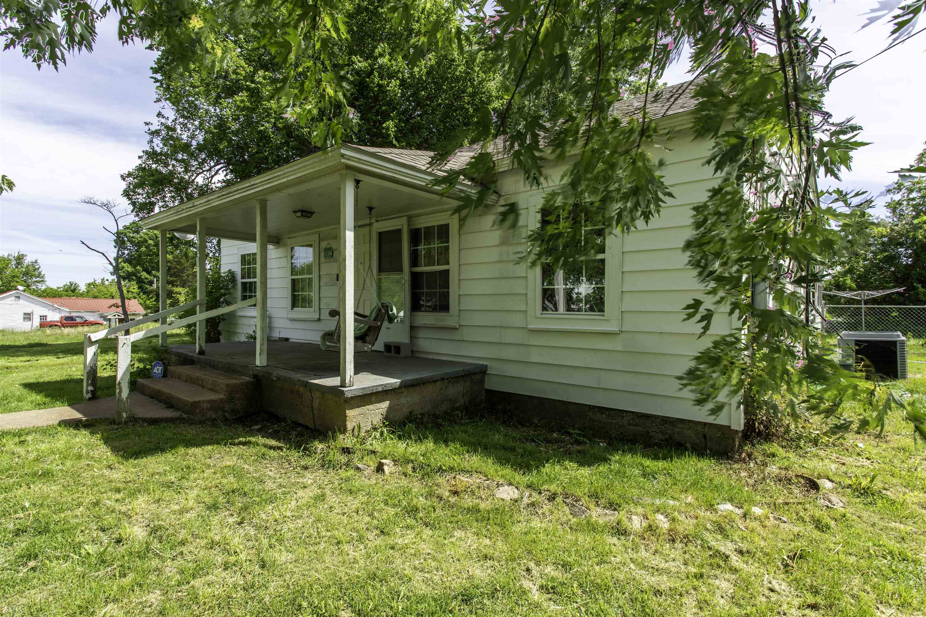 **Country Charm with Shop, Fenced Yard & Shaded Lot**  Full of character and country charm, this craftsman-style home 1,296 sf sits on a beautiful shaded lot in Oxford, Arkansas. From the covered front porch with a porch swing to the old-style wood panel doors inside, warm, welcoming feel the moment you arrive.  The home features a nice sun porch, a screened-in patio in the backyard for outdoor entertaining, and a chain-link fenced backyard that offers great space for pets, kids, or gardening. A 24x24 red iron shop building with 100-amp service provides plenty of room for storage, hobbies, tools, or workspace.  This property has also seen many important updates in the last few years, including most windows updated to vinyl, roof replacement in April 2020, heat pump and ductwork installed in Dec 2020, incoming plumbing replaced with PEX in spring 2021, and fencing installed in spring 2021. Additional updates include new crawlspace bracing in Aug 2023, kitchen windows replaced in 2023, stove replaced in April 2020, dishwasher in 2024, and refrigerator new in 2024.  A home with practical updates, outdoor living space, and a great shop—this one offers the best of country living.