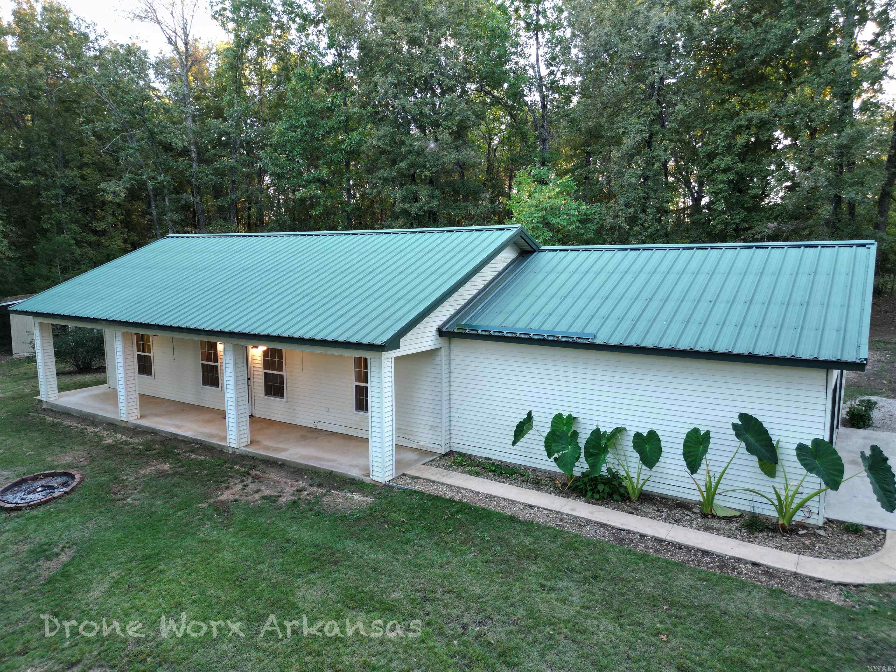 A very manageable and practical 2 bedroom, 2 bath home with a great porch for early morning coffee quiet time, or drinks by the fire pit in the evenings.  With the 1170 square foot home on just under 4 acres, this efficient and classic package deal is just enough for a few animals, but not too large to that it is difficult to manage.   The home's exterior is extremely durable with minimal maintenance.  The open concept living room and kitchen make it so easy to host family and friend gatherings.  The small shed and coop out back is perfect for lawn tools or fill it with your very own egg layers.  Close to the road makes for easy access and convenience and the large garage is the perfect place for your vehicles, projects or more storage.