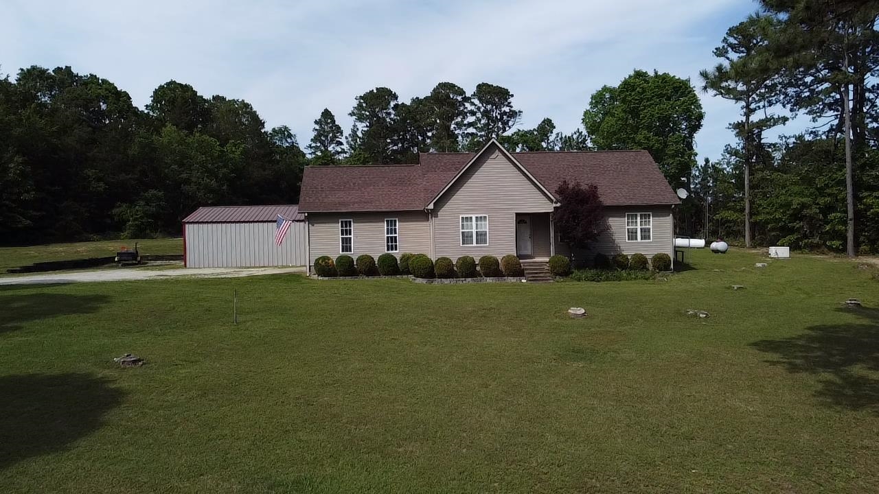 Charming 3 bedroom, 2 bathroom home situated on 3 acres in the Ozarks, offering privacy, functionality, and room to grow. The 1,294 sq ft home features a spacious master suite with walk-in shower, soaking tub, and walk-in closet. A standout feature is the 900 sq ft bonus space connected by a 12x40 covered patio—complete with full bathroom and plumbing in place for a kitchen, including propane lines for a cook stove and fireplace—ideal for guest quarters, in-law suite, or additional living space. The home includes gas tankless (on-demand) water heater, and Next Fiber high-speed internet. Outdoor amenities include a large covered patio with direct propane hookup for grilling, a covered raised bed garden. Conveniently located just 3.5 miles from Melbourne School and near Cooper’s Hawk Golf Course.
