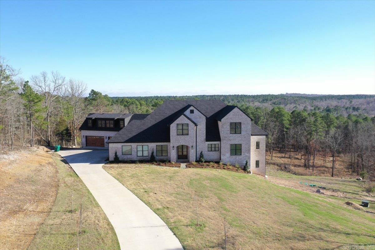 Experience luxury living in this stunning 6,969 sq. ft. custom home nestled at the end of a picturesque tree-lined driveway. This thoughtfully designed property features 6 bedrooms and 5 bathrooms with zoned HVAC systems on each level and a whole-house generator for added comfort and reliability. The main level offers three bedrooms and a beautifully designed kitchen featuring one-of-a-kind quartzite countertops, custom cabinetry with inset doors and soft-close drawers, and a spacious butler’s pantry complete with a second dishwasher, apron-front sink, and additional refrigerator. A large mudroom with built-in benches and storage keeps daily living organized, while the living room opens to a balcony with breathtaking unobstructed views. The primary suite is a private retreat with sweeping views, a spa-like bathroom featuring a wet room shower and soaking tub, quartzite countertops, and a large closet with washer/dryer hookups. Upstairs includes two bedrooms, a bathroom, loft, and theatre room. The lower level offers a bedroom with balcony, full bath, gym, game room, and plumbing for a future kitchen. Above the garage, 1,300 sq. ft. is framed for a 2 bed, 2 bath apartment.