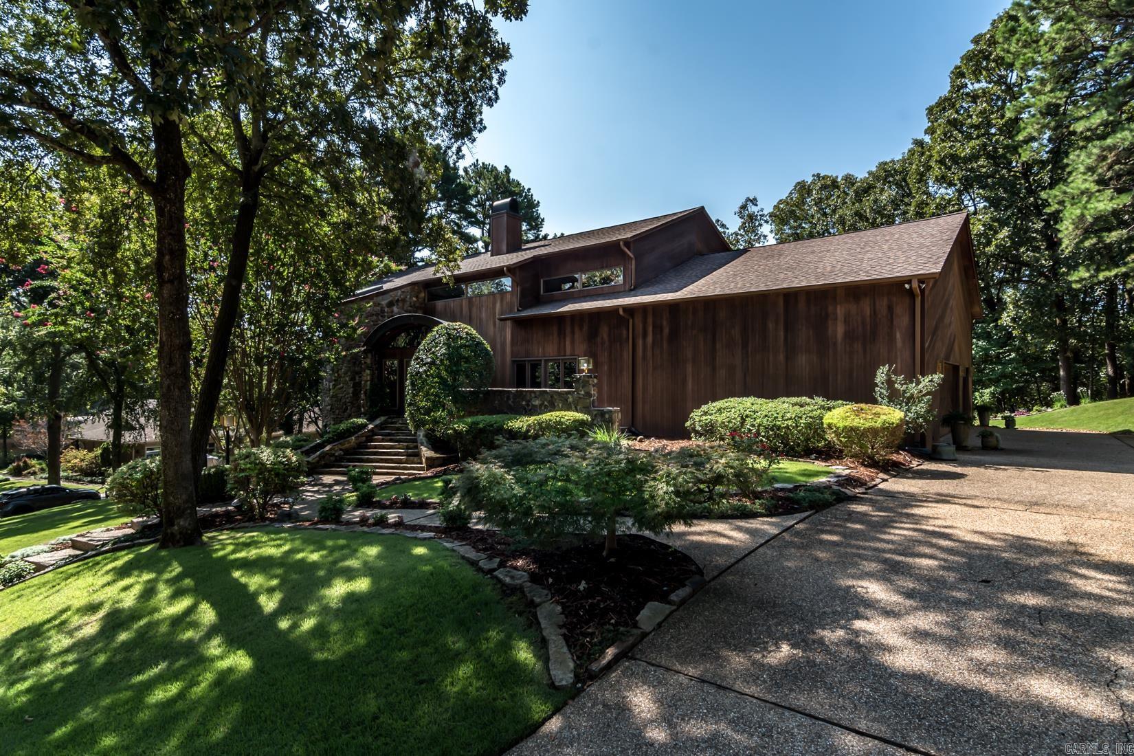 Incredible home located in the exclusive gated neighborhood of Pleasant Valley on a private cul-de-sac constructed out of Arkansas natural stone, redwood, cedar wood and positioned on over an acre cradled by the privacy of beautiful trees and green space. The interior was designed with incredible natural light with Anderson windows and Marvin doors. The main level of this home features barrel ceiling, site finished oak hardwood floors and a soaring fireplace. The two-story great room offers a fantastic space for entertaining with custom built cabinets and a private wet bar. The kitchen was designed by a chef with a wolf gas range, gas oven with warming lights, double ovens, Sub Zero refrigerator and spacious pantry. The owner's suite is located off the great room and features a fireplace, renovated bathroom, walk-in closet and private balcony. Upper level features a casual den, game room, hobby room and two bedroom suites. Special features include a spacious three-car garage plus work space. The backyard features beautiful landscaping, cedar deck, screened-in porch, and breathtaking views of the natural forest.