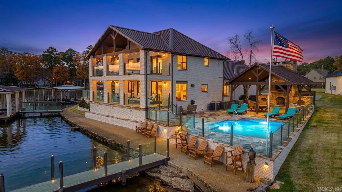 Welcome to your lakefront dream home on the shores of Lake Hamilton Arkansas. This stunning 3,419 square foot home offers 4 spacious bedrooms, 3.5 baths with high-end updates throughout. Enjoy 180-degree panoramic views of the lake from both upper and lower covered porches. The custom boat dock is complete with a heavy-duty overhead cradle boat lift and a dual personal watercraft dock. This is a rare legacy home ideal for family memories or beautiful sunsets on your private pier. Entertain all summer in the in ground heated pool, gather in the game room or enjoy the covered patio with a wood burning fireplace and a custom bar and grilling station. The 22kw back up generator and additional split AC keep things comfy no matter the weather and the kitchen offers a large side by side fridge & freezer, wall oven and microwave combo, mini beverage cooler and a handy under counter ice-maker with beautiful granite counters, custom lighting and plenty of extra cabinet space. It’s a once in a lifetime opportunity … act now and be ready to enjoy your new lake home by Summer.
