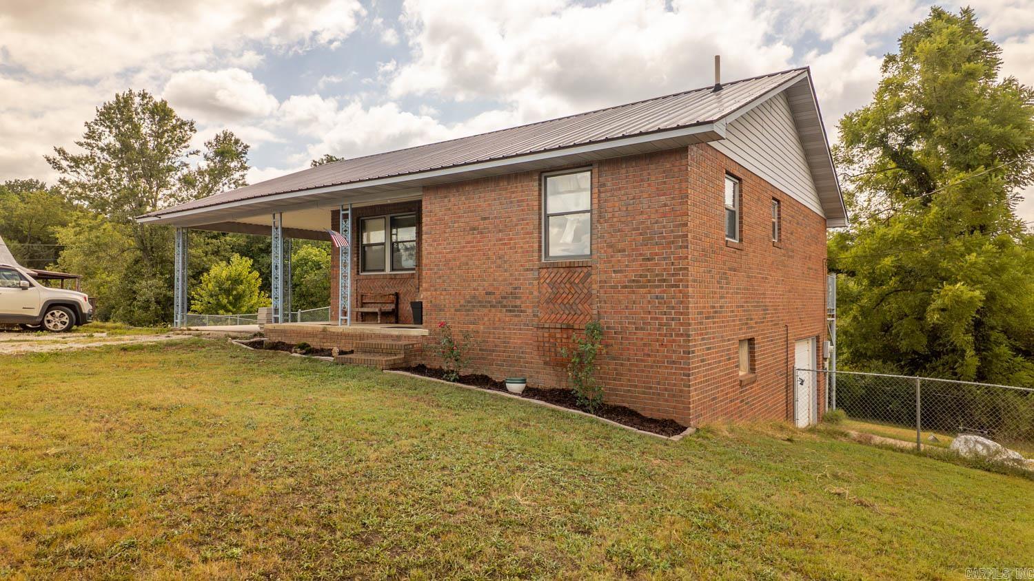 Home for Sale Near Spring River  Nestled in the heart of the Arkansas Ozarks, this charming 3-bedroom, 2-bath brick home offers comfort, convenience, and versatility. Located on a quiet street with only a few nearby neighbors, the property provides a peaceful setting while remaining less than a mile from the Spring River and Mammoth Spring State Park. Enjoy easy access to fishing, kayaking, floating, hiking, and other outdoor recreation year-round.  Inside, the home features an open-concept layout that creates a spacious and inviting atmosphere. The kitchen is equipped with granite countertops and flows seamlessly into the living and dining areas, making it ideal for entertaining or everyday living. The master suite includes access to a balcony-style back porch overlooking the large fenced backyard situated on a corner lot.  Additional features include central heat and air, a durable metal roof, and a carport for covered parking. The basement offers excellent potential for a fourth bedroom, office, hobby room, or additional storage. Whether you're looking for a full-time residence, retirement home, or weekend getaway, this property offers Ozarks living at its best.