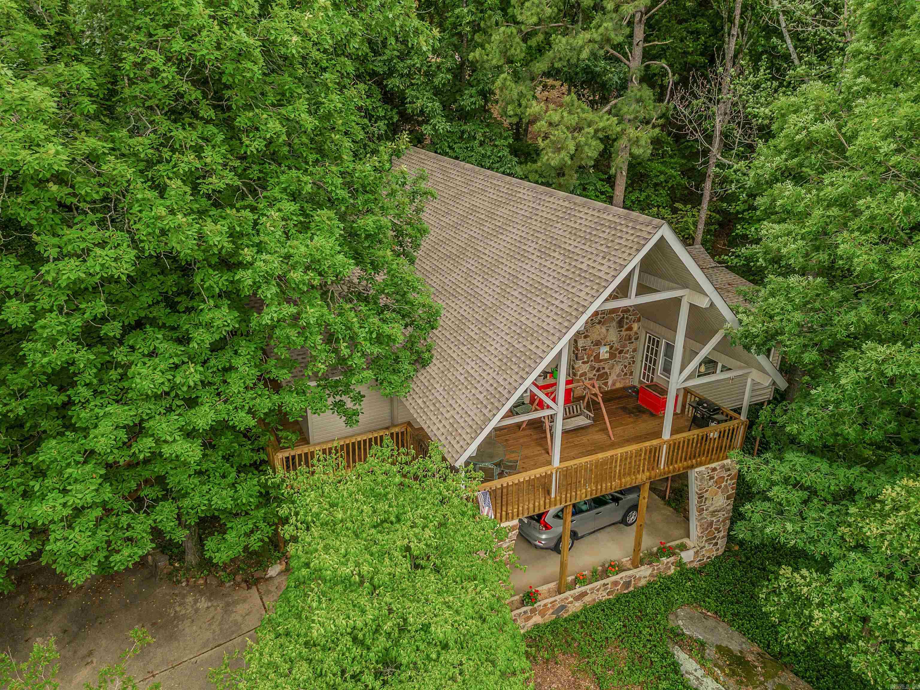 VIEW OF GREERS FERRY LAKE & SUGARLOAF ISLAND  are enjoyed from this unique home.  You'll enjoy hours out on the expansive deck enjoying scenic sunsets, wildlife, and the natural surroundings.  Over 2500 sq. ft. offers a great room with woodburning fireplace, a wall of windows to capture the view, updated kitchen/dining areas.  Custom cabinets in kitchen, lots of counterspace, appliances included (refrig-freezer, NEW dishwasher, trash compactor, electric range & microwave oven).  Adjoining the kitchen is a sizable laundry room with pantry, cabinets, desk.  This level has a half bath, plus the Master suite.  The Master Bath was recently updated with step-in shower.  The 2 Guest BR and a Guest Ba are upstairs.  Need a game room or hobby room, den, or extra sleeping space?  The lower level has a large bonus room for these uses.  The flooring is oak hardwood, tile, vinyl, carpet.   The Roof was replaced in early 2024.  HVAC is "dual fuel" and maintained semiannually.    The new owner will have Member access to all Fairfield Bay Resort-owned amenities.  Seller would possibly need Delayed Possession.  Call to schedule your appointment to take a personal look!