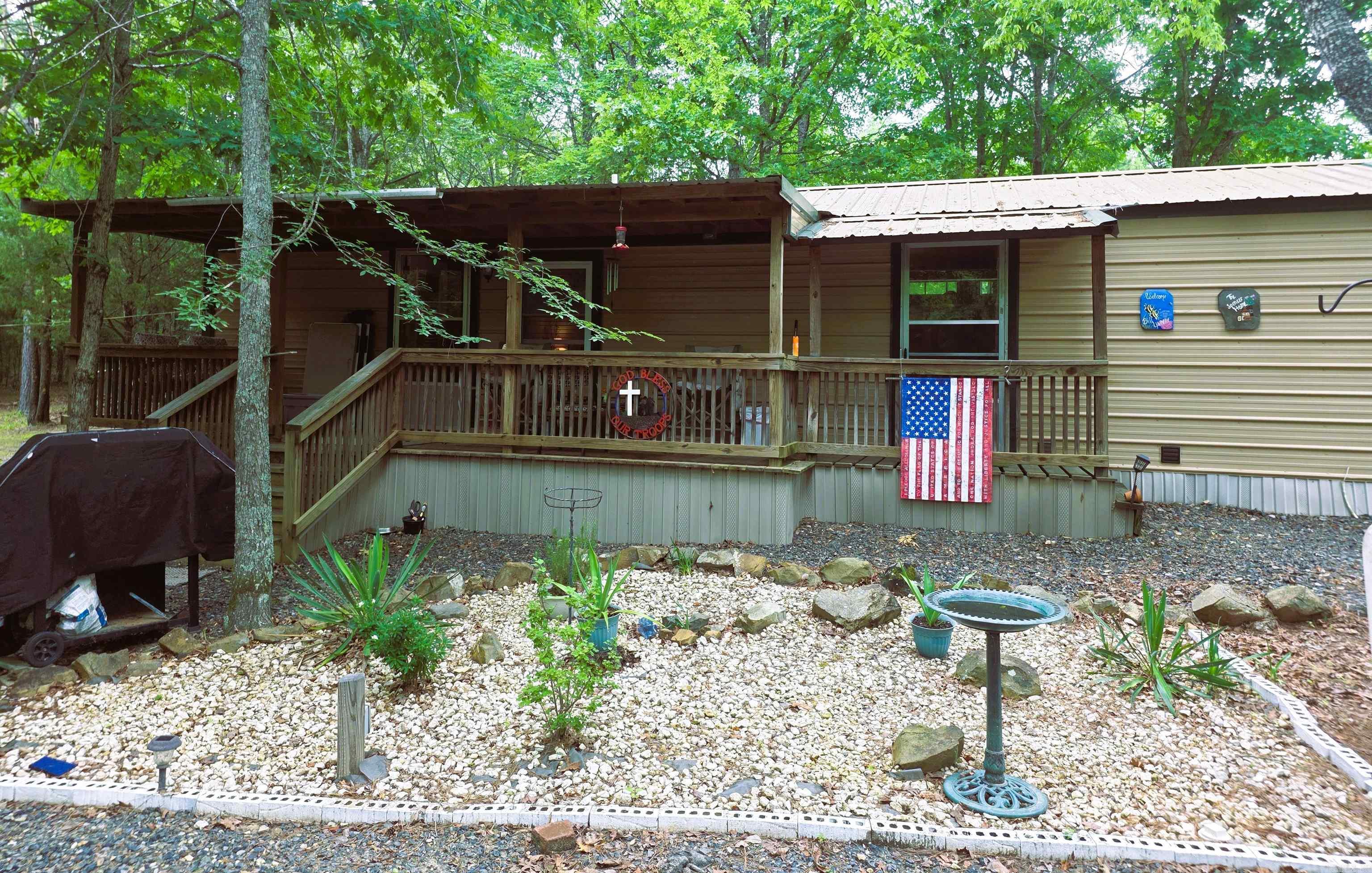 Dream Cottage on Iron Mountain – Peaceful Living with Income Potential Welcome to your private mountain retreat! This charming metal building cottage, located just minutes from Mena, offers the perfect blend of serene mountain living, practical homestead features, and excellent income-producing potential. Tucked away on 5 fully fenced pristine acres, this unique property sits only one mile from the popular CMA Campground. It's ideal for homesteaders, investors, outdoor enthusiasts, with real earning power. Step inside this cozy home and enjoy thoughtful details like a massive 8' walk-in closet with safe for exceptional storage. The property is being sold fully furnished, including all appliances and a premium adjustable Queen bed. Outside, the magic continues. Relax on the inviting front porch with its classic porch swing. Gather around the fire pit on crisp evenings for unforgettable nights under the stars. The land itself is a beautiful mix of mature woods, cleared open spaces, and a charming wet-weather pond. The property features 2 metal workshop sheds (6x12 and 10x16), 8 RV hook ups, 10,000-watt back-up generator, Zero-turn mower and trailer included with full purchase price!
