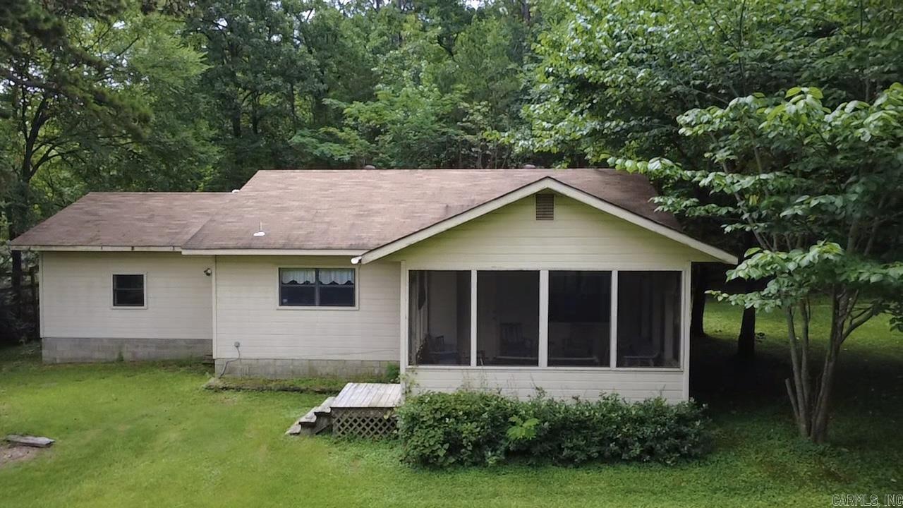 This cozy bungalow, with 1 bedroom and 1 bathroom, has a perfect floor plan that maximizes small-space living. It features a large garage, a laundry room with a sink, and an open floor plan. The screened-in porch beckons you to enjoy the outdoors, free from pests. Although close to the highway, the house property is private, surrounded by woods with a year-round stream on the north boundary. A new high-performance HVAC system was installed in 2025. A new roof in 2021. ADA accessible. The adjoining shop, with property on the corner, is included in this listing. High visibility is a bonus for a potential business. Improvements are needed. See MLS #25032130 for the house with land only.