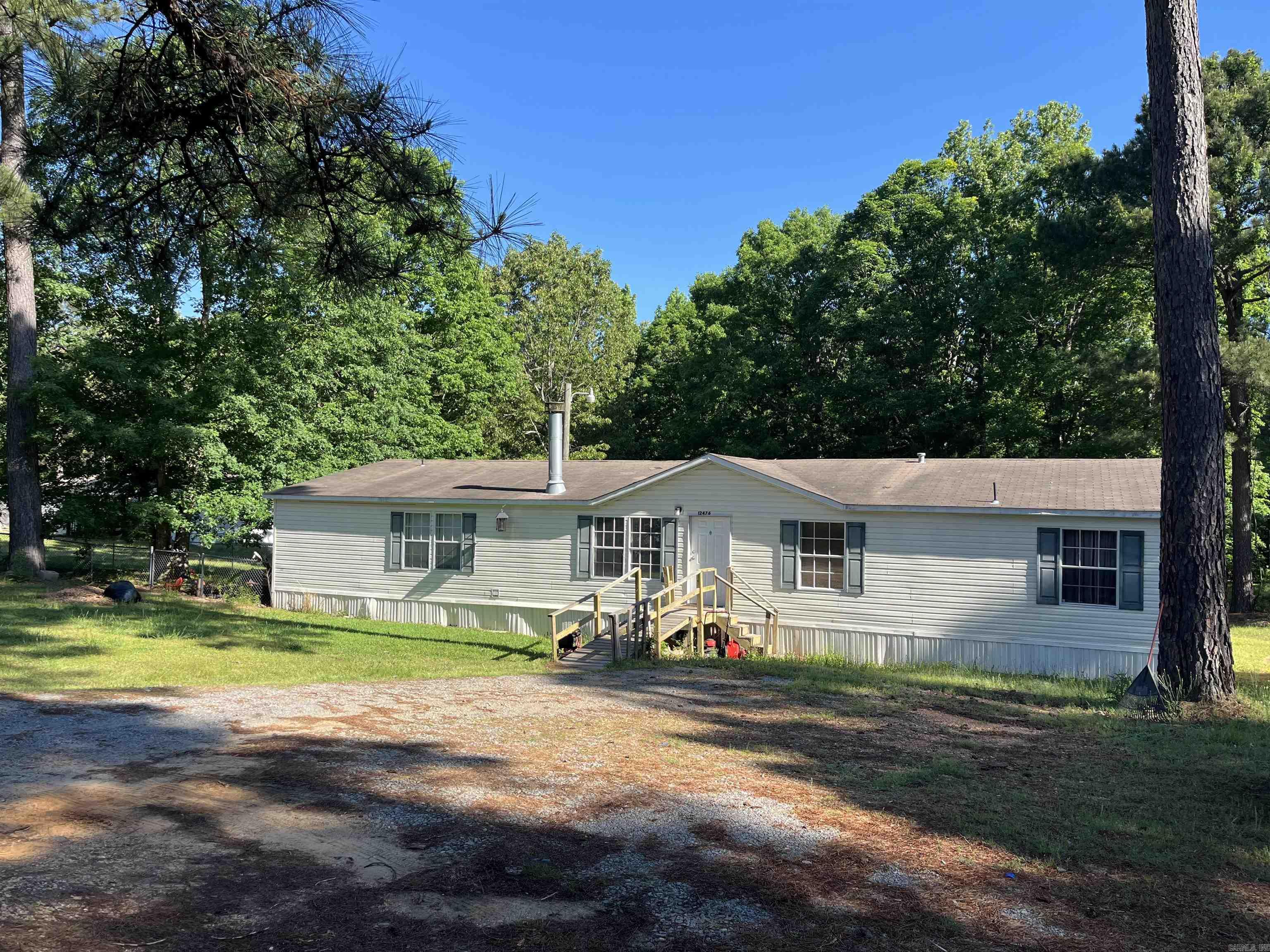 Escape to your own piece of country paradise! This charming 2005 double-wide mobile home sits on approximately 1.09 acres. With 5 spacious bedrooms and 3 full bathrooms, there's room for everyone to relax and enjoy. The open-concept living area creates a welcoming space for family gatherings or quiet evenings in front of the cozy corner fireplace.  Step outside to find plenty of space to unwind—whether it's enjoying the fresh country air, gardening, or letting your pets roam in the fenced portion of the yard. There’s so much potential here to turn this into your dream country home with some TLC.   *Please See Agents remarks*