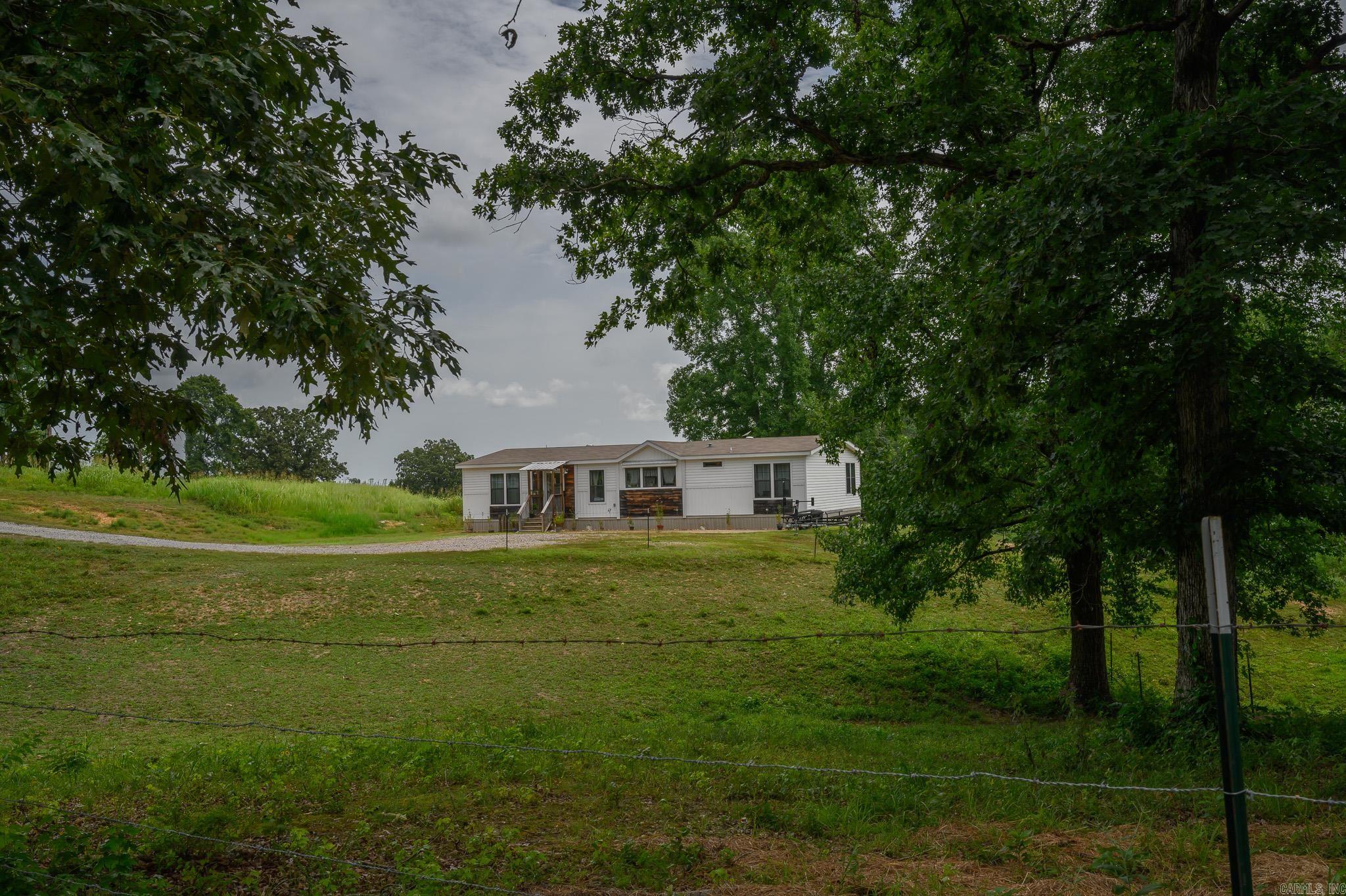 Nestled on just over 17 picturesque acres in Mount Ida, Arkansas, this property offers the perfect blend of rolling pastureland, mature shade trees, & a peaceful creek that winds through the landscape. Whether you're dreaming of a hobby farm, horses, or simply enjoying the privacy & beauty of country living, this property is ready to make those dreams a reality. The property features a barn with two stalls, a tack room, & a separate storage room, while the gently rolling terrain provides plenty of room to roam. Inside, you'll find a thoughtfully designed home filled with natural light. A unique entryway creates a warm welcome, leading into an open-concept living area. The spacious kitchen features a movable island, offering flexibility for meal prep & gatherings. Off the primary suite is a rustic-inspired bathroom & walk-in closet. Oversized laundry room with extra storage. This property offers the tranquility of rural living just minutes from Mount Ida's outdoor recreation, crystal mining, Lake Ouachita & the Ouachita National Forest. Just over a mile to the Police Station, Fairgrounds & Elementary School. Less than 2 miles to the grocery store, bank & more!