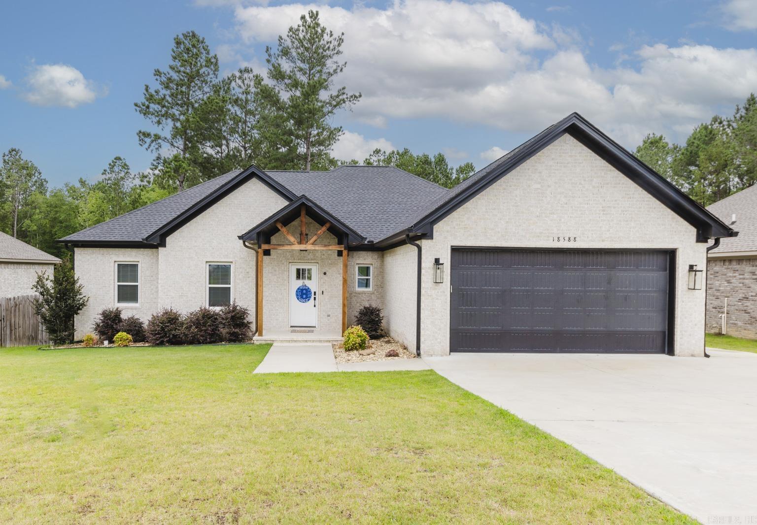 This stunning custom-built home in the Bryant school district offers four spacious bedrooms and two bathrooms. The open floor plan invites you into a large living room and eat-in kitchen featuring an island with a breakfast bar and gas stove. Outside, enjoy a fenced-in backyard and a covered back patio, perfect for relaxing or entertaining.  Experience the peace and quiet of being away from the town center, with the added serenity of backing up to a wooded area. The subdivision features a walking trail, a community area with picnic tables, and a basketball court.