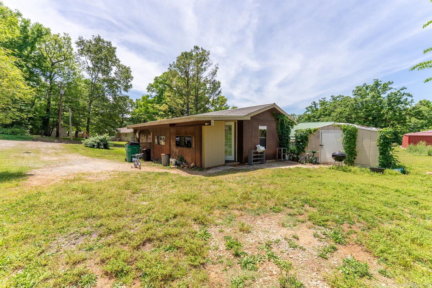 Country Home Near Spring River | Hardy, Arkansas  Welcome to this two-bedroom, one-and-a-half-bath mobile home situated on two lots in the heart of Hardy. Whether you are searching for an affordable full-time residence, weekend getaway, or investment opportunity near the river, this property offers convenience, comfort, and potential all in one location. Inside the home, you will find an open floor concept that creates a spacious feel between the living, dining, and kitchen areas, making it easy to gather with family and friends. The home features two bedrooms, one full bathroom, and an additional half bath for added convenience. At the front of the home, a welcoming deck provides the perfect place to relax with your morning coffee or enjoy quiet evenings outdoors. Toward the back of the house, a bonus room/mud room adds extra functionality and could serve as additional storage, hobby space, or a flexible area to fit your needs. The property also includes a 12x8 utility building for tools, lawn equipment, or additional storage space. Central heating and cooling are installed, and the home is equipped with propane heat for dependable comfort throughout the seasons.