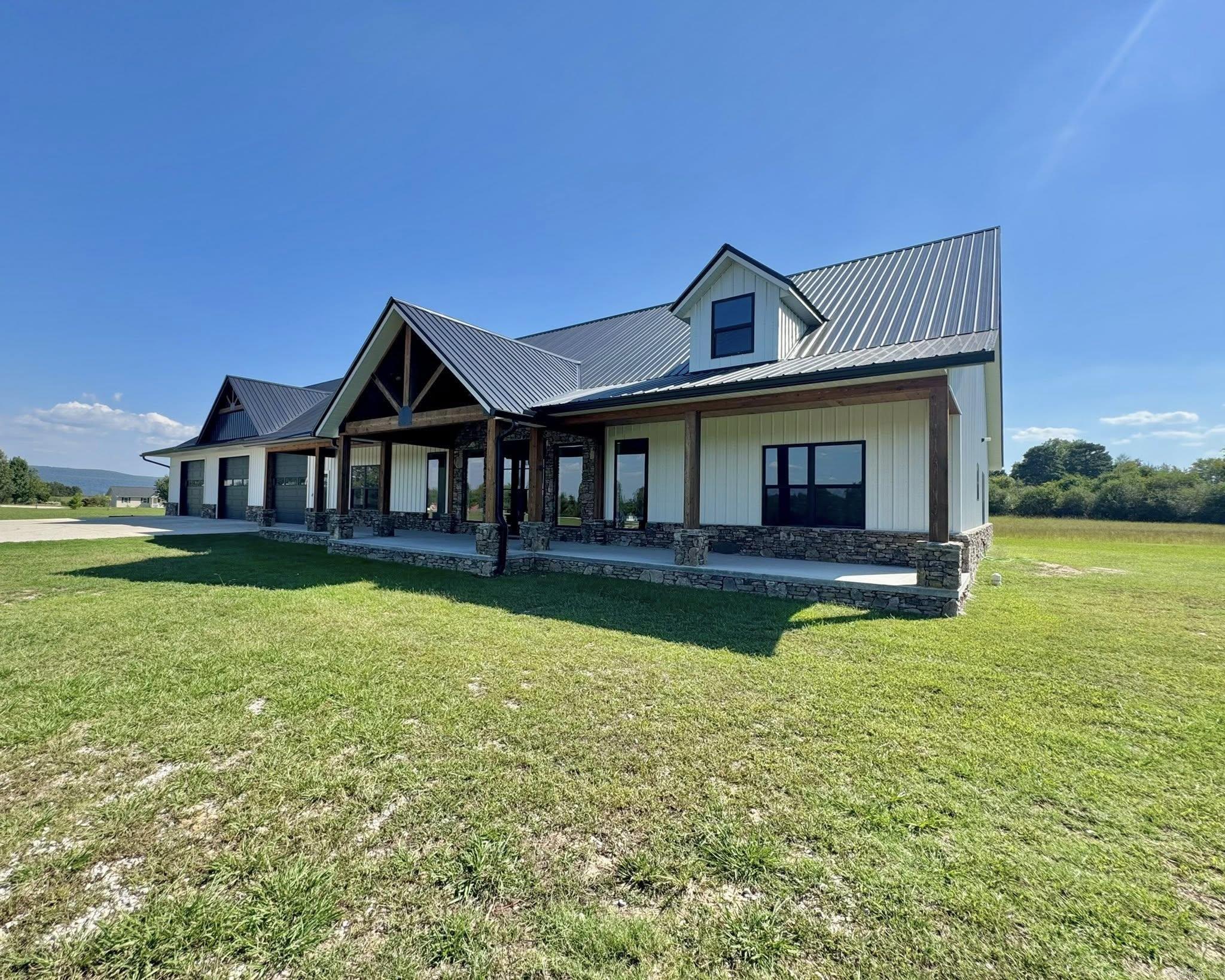 Just outside the city limits of Mountain View, this impressive 3200 sq ft barndominium as well as a 3200sf attached 3 bay garage with multiple possibilities, farmhouse charm on 6 unrestricted acres. The home features 4 bedrooms and 3 full baths, designed with both comfort and function in mind. The open-concept great room is anchored by a cozy propane fireplace, creating an inviting gathering space, while double barn doors cleverly conceal the laundry area. A bonus room above 3-bay garage is approximately 1200sf which is just storage but has so many possibilities. Enjoy a sweeping driveway—over half concrete—and the freedom of unrestricted land. The property is already equipped with a second septic system, water, and power hookup, making it well-suited for adding a shop, guest house, or second home. Located just minutes from downtown Mountain View and its iconic free weekend music scene, this property perfectly balances rural privacy with vibrant small-town culture. Some finish work remains, which is reflected in the price