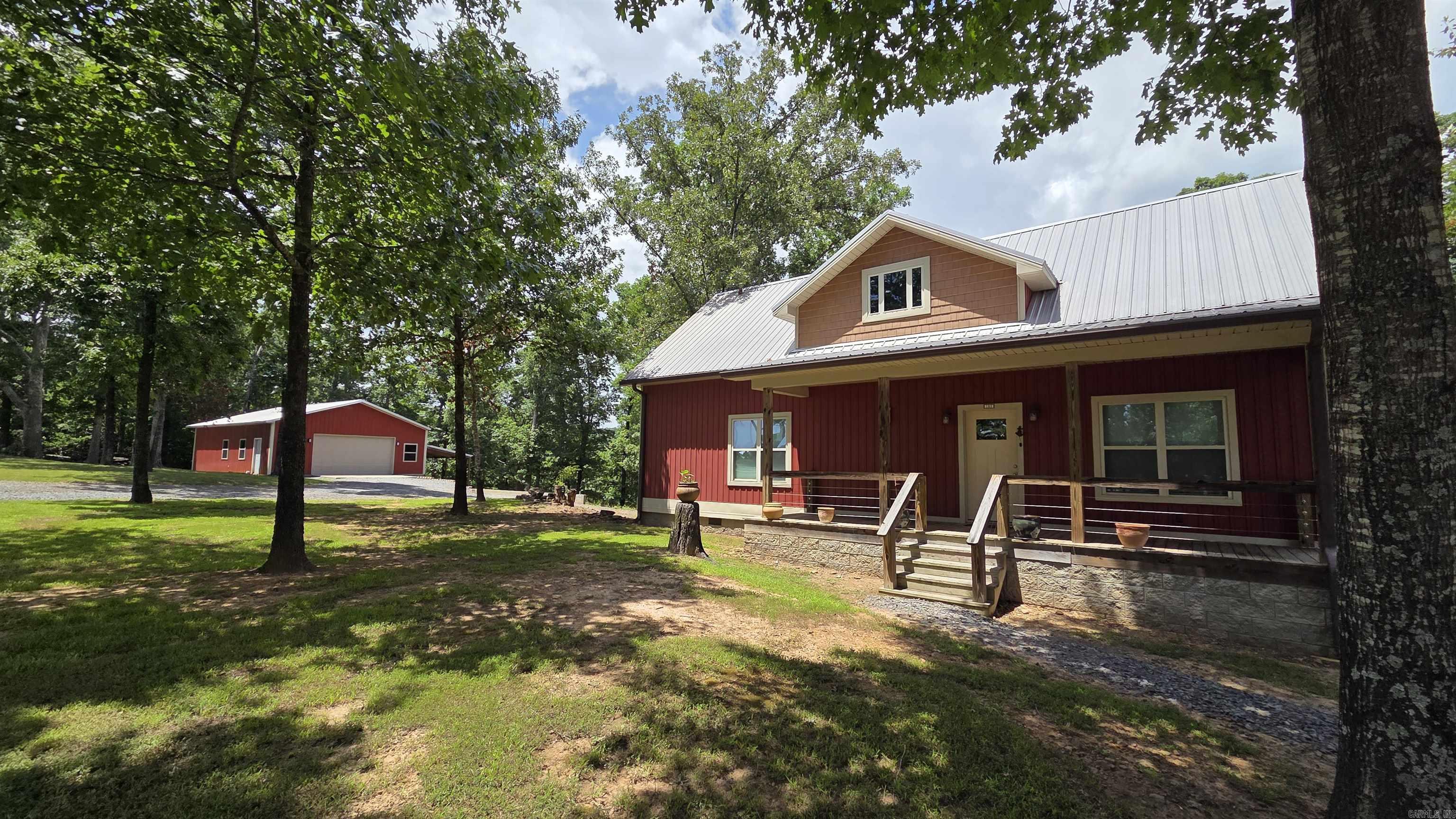 Lake View living in a one of a kind, Original-owner home perched above Greers Ferry Lake. Perfect for full-time living or weekend getaways. Main level features hardwood floors, stylish finishes, a stone hearth with blower-equipped wood stove, and a primary suite with double French doors opening onto a full-length covered deck with lake views. A clean 2022 Therma-Spa hot tub sits ready on the deck. Kitchen, laundry, and living areas are all on one level. Upstairs offers a full bath and two bedrooms, including a long bunkroom ideal for guests. Outside: matching 30×40 fully insulated garage/shop with electricity throughout, abundant interior and exterior outlets, automatic door, and a 12×40 lean-to. Also includes a 20×30 boat shelter and RV electrical hookup. Peaceful setting with practical extras made for lake life.