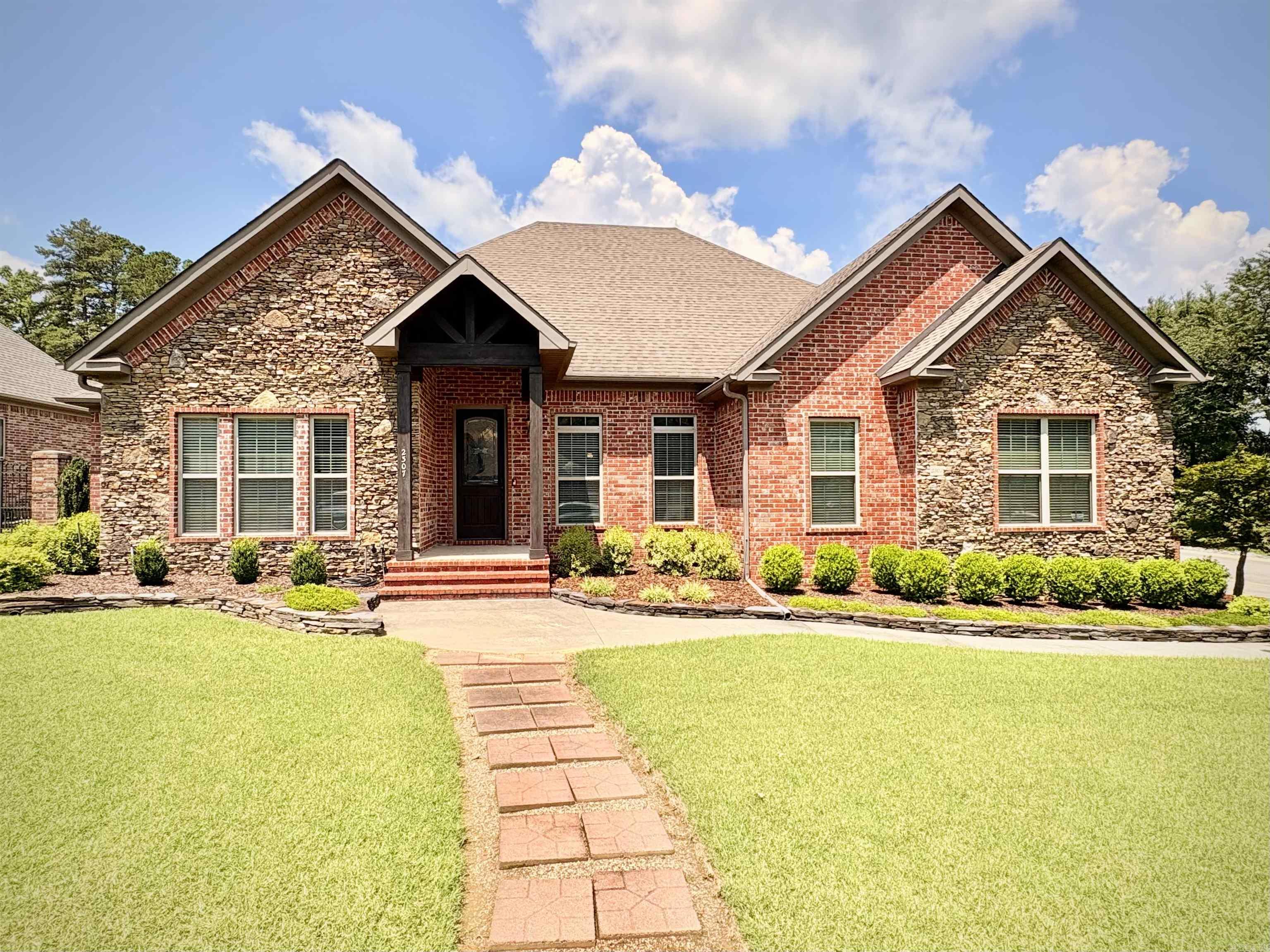Nestled on a corner lot in the Valley Court neighborhood near Searcy Country Club, this beautiful 4-bedroom, 3-bath home combines thoughtful upgrades with classic craftsmanship by Steve Ward. Hand-scraped hardwood floors and tray ceilings lead through bright, open living spaces. The open floor plan makes entertaining easy, with a cozy dining area flowing seamlessly into the living room. The kitchen checks all the boxes for custom builds, while a sunroom and a SunSetter awning cover the patio, creating a peaceful escape to the beautifully landscaped backyard equipped with a sprinkler system. Entering from the two-car garage, you’ll find an easy-access entry to complement the level entrance through the front door. The primary suite features a zero-entry (curbless) shower, a luxurious en-suite bathroom, and a spacious walk-in closet. Two additional bedrooms share a Jack-and-Jill bath—ideal for family or guests—which includes another walk-in shower, while the fourth bedroom makes the perfect home office. Rest easy knowing the HVAC was replaced in 2025 and the roof in 2014. Located close to Westside Elementary and Harps Food Premier, this home is move-in ready and waiting for a family.