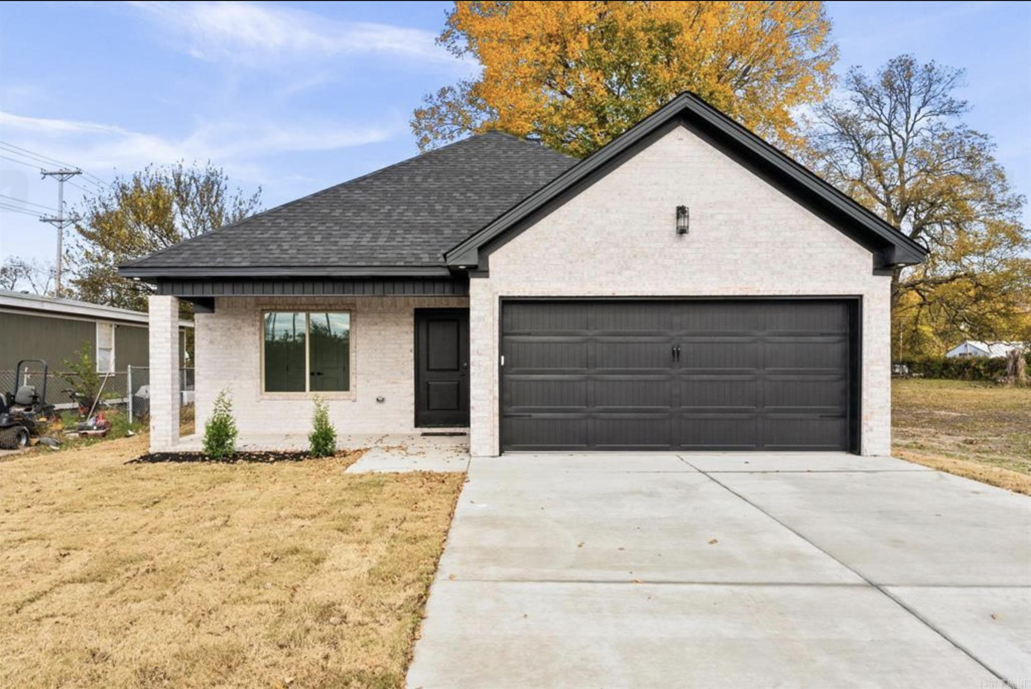 This beautifully maintained all-brick home offers low-maintenance living with stylish modern finishes throughout. Eye-catching dark soffit and fascia accents, professional landscaping, and a covered front porch with wood-paneled ceiling and ambient lighting create great curb appeal.  Inside, the home features wide-plank flooring, crown molding, recessed lighting, and a bright open layout. The spacious living room includes custom built-ins and easy access to the backyard patio, making it perfect for relaxing or entertaining.  The kitchen is equipped with granite countertops, custom cabinetry, tile backsplash, Whirlpool appliances, pantry storage, and bar seating for casual dining.  The primary suite offers a walk-in closet and a beautifully finished bathroom with granite vanity, upgraded fixtures, and a custom tile walk-in shower. Two additional bedrooms provide generous space, built-in storage, and abundant natural light.  Enjoy the fully fenced backyard with privacy fence, walk-through gate, and patio area ideal for outdoor gatherings, pets, or play space.