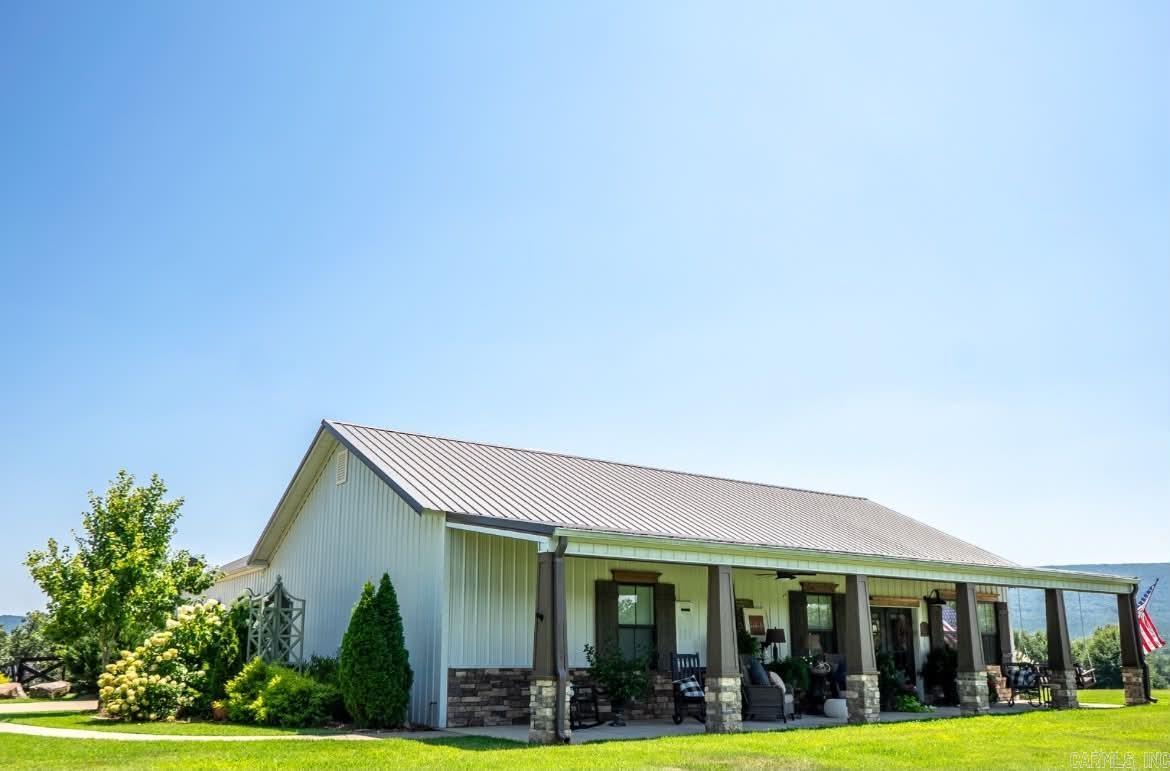 Beautifully built, luxurious custom home on 28.88 acres bordering the National Forest. This stunning 3-bed, 3-bath home offers approximately 2,568 sq ft of thoughtfully designed living space with vaulted ceilings, wood-burning fireplace, floor-to-ceiling window wall framing breathtaking mountain views, shiplap accents, and knotty pine and maple custom cabinetry throughout. Kitchen features granite countertops and gas stove. All three bedroom suites include their own bathroom with heated floors. Additional highlights include 3/4 knotty pine interior walls, Karndean flooring, adjustable built-ins, loft office, and storm shelter in the primary closet.  Outside, enjoy a 30x60 shop with lean-to, 16x12 greenhouse, storage garage, in-ground pool, rock patio with fire pit, and a 560 sq ft loft above the shop perfect for guests or multi-generational living. The acreage features mountain views, stocked pond, tower blinds, hunting stands, and direct National Forest boundary access. Refrigerator, washer and dryer, and loft furniture convey.