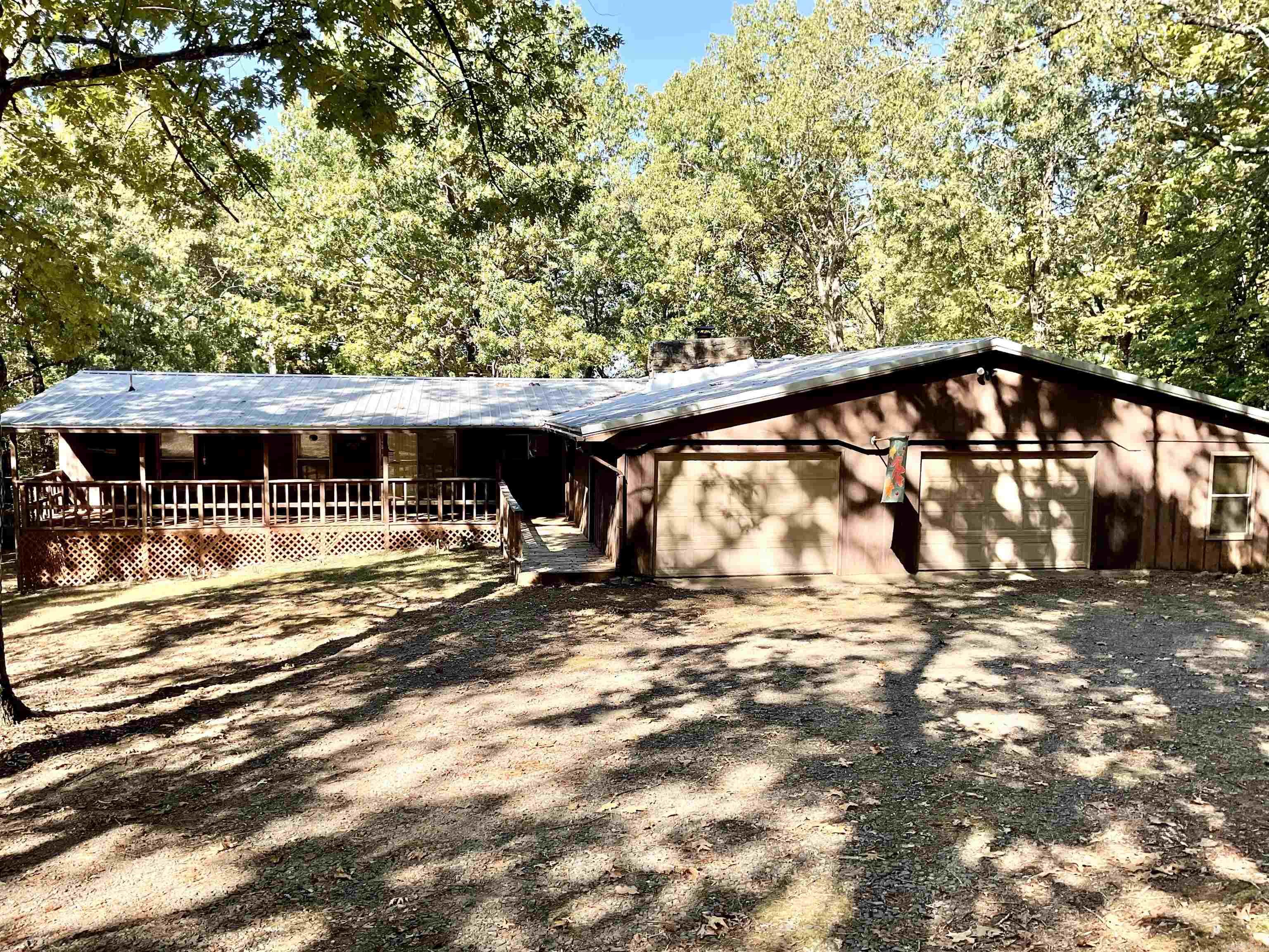 Cabin in the woods! LAKEFRONT with gentle walk to the water, 1.20 acre lot and not in a subdivision! Plenty of room to sleep a group of people! 4 bedrooms and a large sun/dining room with a wall of windows. Large back deck with rocking chairs for outside enjoyment. Main part of home is central heat and air, the built on rooms have window air and space heaters. This home comes with the furnishings you see  even the  dishes. Kitchen has a Jenn air down draft and all appliances convey. Ready to enjoy even through the winter with the wood burning heat unit. Ceiling in the living and kitchen is vaulted, big front and back porches and lots of privacy. Large two car attached garage. 2 outbuildings, one for toys and one for tools and stuff.