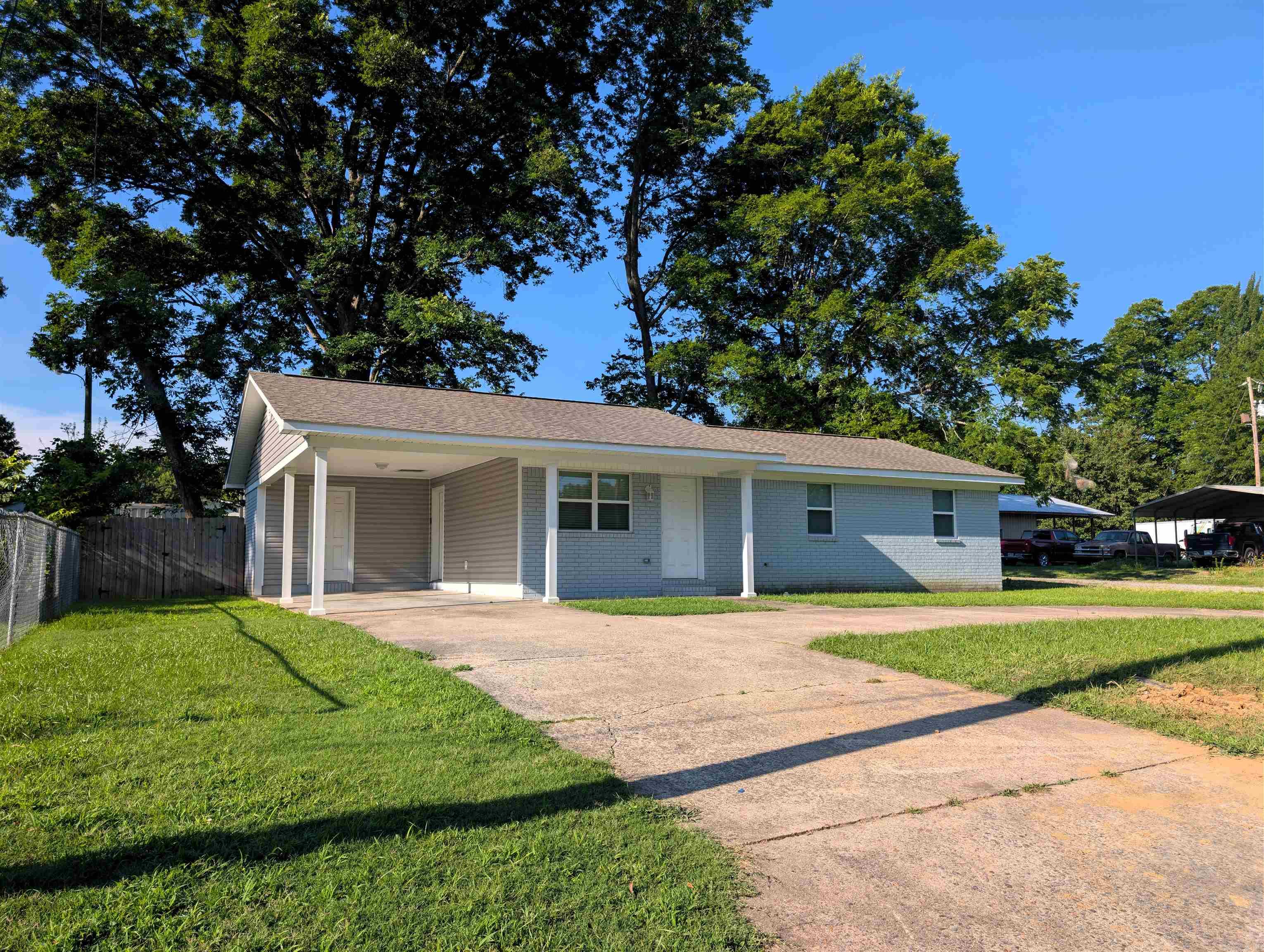 Completely renovated from top to bottom, this 3-bedroom, 1-bathroom home provides low-maintenance living. Virtually every major structural, cosmetic, and mechanical component is brand new as of 2023. The home’s exterior combines classic brick and new siding with a practical built-in carport that includes a secure utility closet. The entry has an open floor plan unified by Luxury Vinyl plank and fresh trim. All three bedrooms continue the seamless flooring and are detailed with modern grey paint, updated six-panel doors, and new ceiling fans. Tucked away in a dedicated alcove is a laundry space for a full-sized washer and dryer, providing added convenience.