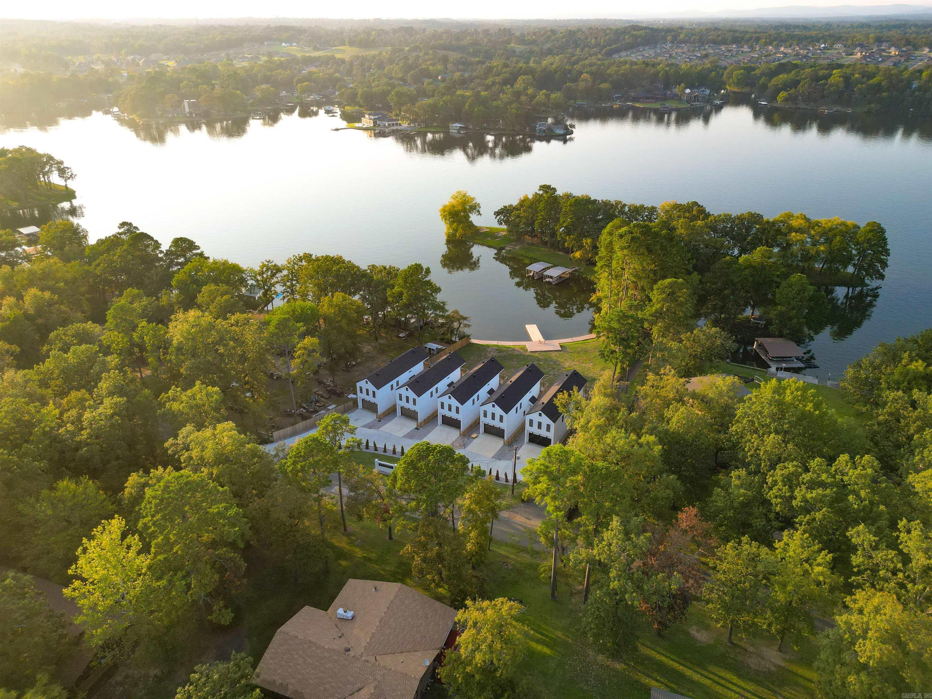 TURNKEY 4-UNIT LAKEFRONT INVESTMENT PORTFOLIO – PRIME LAKE HAMILTON LOCATION Rare opportunity to acquire a fully stabilized four-unit luxury townhome portfolio on Lake Hamilton’s coveted North Shore. These brand-new construction units (2024-2025) in Boll Estates II offer immediate cash flow potential with zero short-term rental restrictions in one of Arkansas’s highest-demand vacation markets. INVESTMENT HIGHLIGHTS: • 4 identical luxury townhomes totaling ~6,676 sq ft • Direct Lake Hamilton waterfront with private dock, pier & boardwalk • NO STR RESTRICTIONS – Operate as vacation rentals from Day 1 • New construction = minimal CapEx for years • Strong year-round rental demand from Oaklawn, Hot Springs tourism & lake recreation • Lake Hamilton School District appeals to long-term tenants • Sell units individually or hold as portfolio UNIT SPECIFICATIONS (Each): • 3 BR / 2.5 BA | 1,694 SF | 2-Car Garage • Contemporary 2-story with 10-ft ceilings • Floor-to-ceiling Andersen windows with panoramic lake views • Quartz counters, stainless appliances, LVP flooring • Private deck overlooking Lake Hamilton • Second-floor laundry **FURNITURE AVAILABLE FOR ADDED COST
