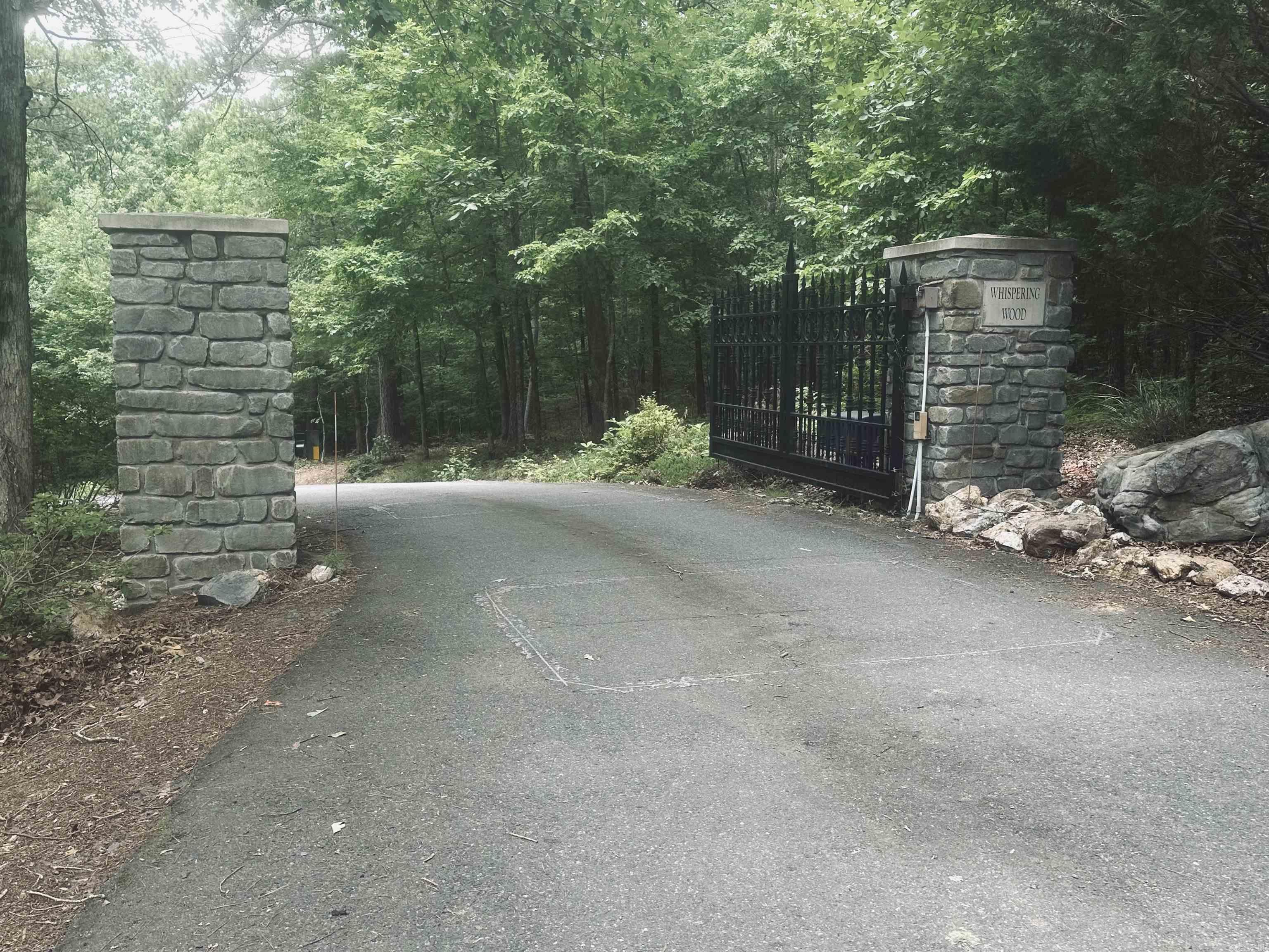 Last call! Last lot available in this exclusive gated subdivision of all custom homes just on the outskirts of Chenal off Ferndale Cutoff and Studer Rd. The developer has done a significant amount of improvements.. multiple culverts, drainage and elevated driveway laying the foundation for a one of a kind driveway entrance that runs alongside and crosses a creek before you traverse the mountain. At the top you will find total privacy with a level building site to build your dream home with mountain valley and vista views. One single family 3,000 SF minimum residence per lot. All utilities underground. No front loading garages. Up to 4 horses per lot, no farm animals, household pets welcome! Property owners are responsible for the proper care and upkeep of the private road and entrance in Wihispering Wood.. Come take a look!