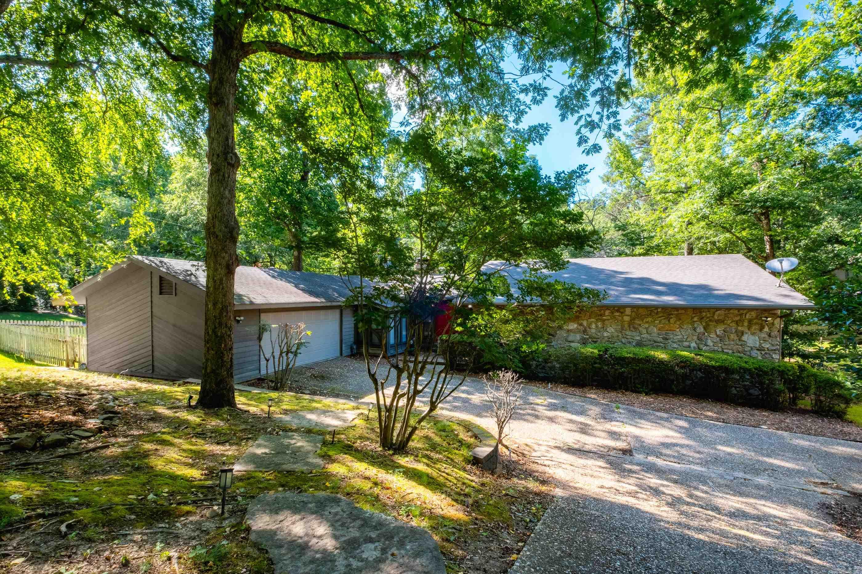 One level mid-century home on corner lot with TWO garages! The large great room features vaulted ceiling, stone fireplace with gas logs and wall of windows overlooking screened porch and deck. Formal dining for those special occasions or use as an office/media room. The large kitchen has ample storage space & island. There is a laundry room that is currently being used as storage with an additional location in the hall by the bedrooms. All bedrooms are large and master offers big walk-in closet, bath with double vanity. HVAC 2013 yrs. Roof 2015, floors & H/W 2017. Attached 2 car garage + 2 car detached garage.