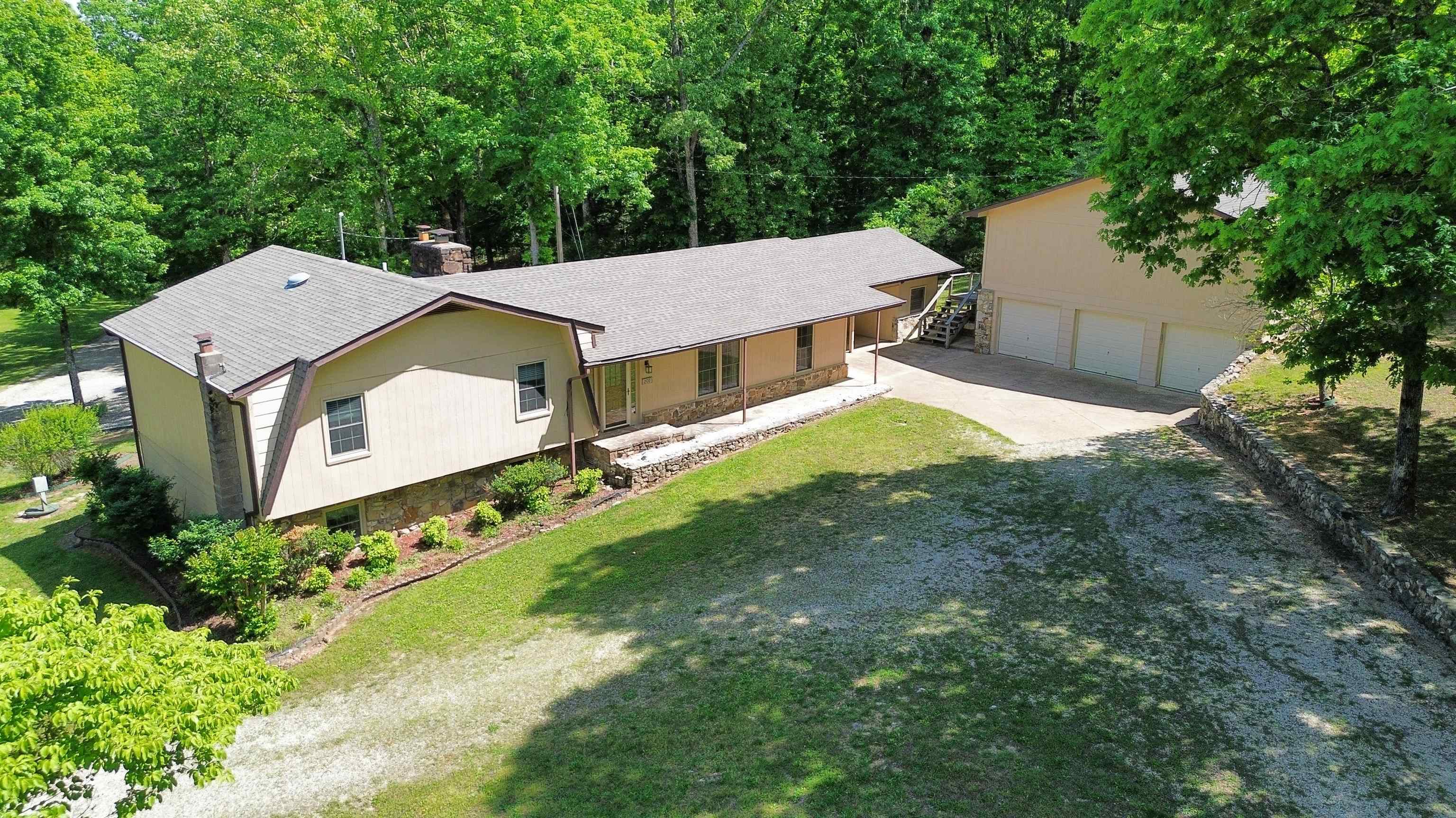 Cradled in your own private corner of the Ozark hills & spread across 13.62 surveyed acres, this Rainbow Lake home welcomes you like an old friend-quiet, peaceful, & full of country charm. Deer wander the ridge at sunrise, turkeys cross the clearing, & the world feels still yet downtown Hardy & the Spring River are less than five minutes away. Walk into the foyer with the rock floor flowing into the fireplace to set the tone, warm wood floors, vaulted living room ceiling. Custom kitchen, cabinets stretching along walls like they were built for a lifetime of family meals, porcelain tile floors & breakfast bar feels like the place where stories are shared. Step onto the screened-in porch and breathe in the peace only country living can give. Upstairs holds 2 bedrooms & 2 baths plus a spacious primary suite with a large walk-in closet. Downstairs gives you another bedroom, a bonus room for a possible 4th, a full bath, laundry, & even a laundry chute from above. Outside sits a detached 3-car garage with a huge upstairs space ready for an apartment, game room, or whatever you can dream up. With a 2022 architectural roof, city water & sewer, and a mix of cleared land & private woods!