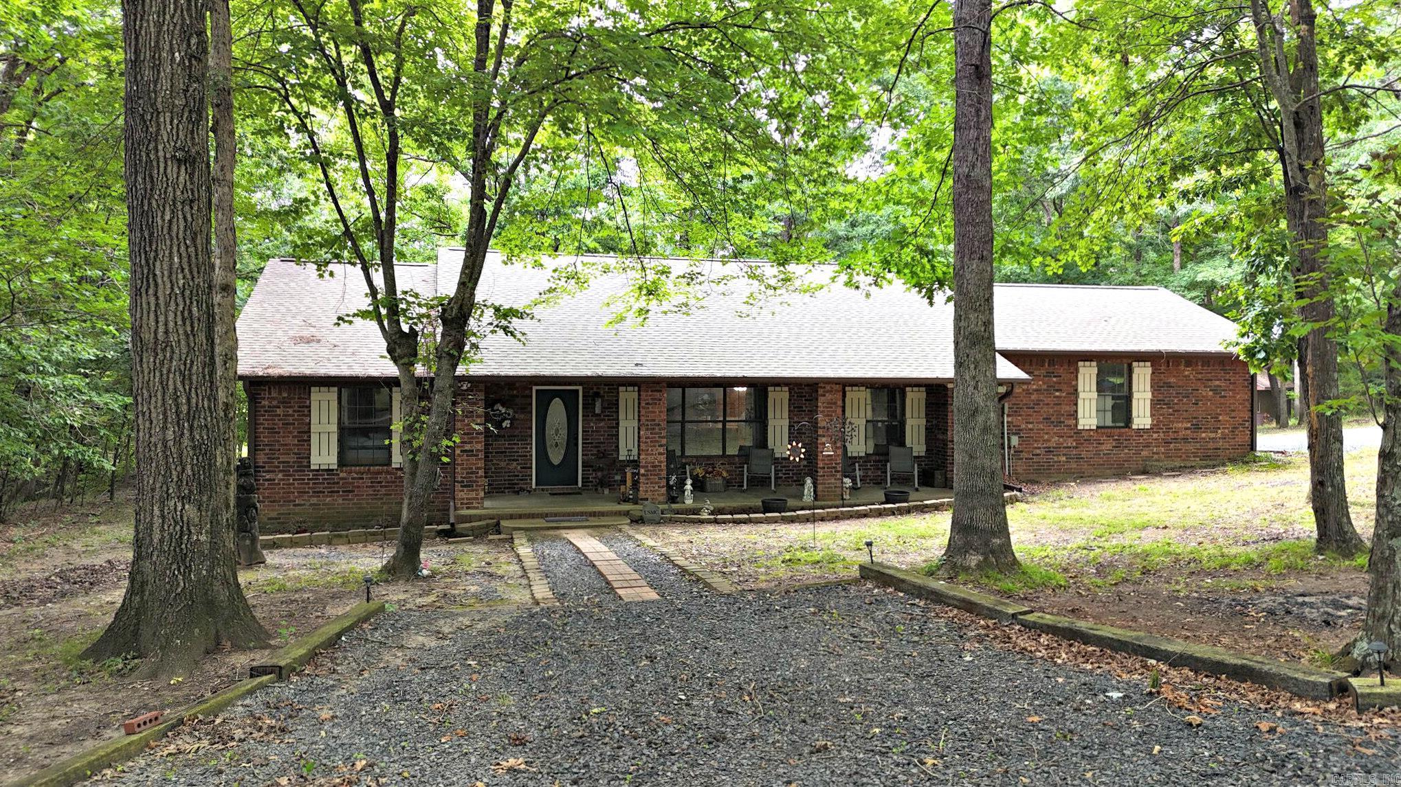 Beautiful brick home on 3 wooded acres just minutes from Mena, Arkansas, set in a peaceful parklike setting with a small creek and the privacy buyers are searching for. This well-kept 3 bedroom, 2 bath home offers 2,325 square feet of comfortable living space, a clean updated interior, and tons of storage throughout. Enjoy the outdoors from 1,129 square feet of decking, perfect for relaxing or entertaining while taking in the natural surroundings. The property also includes an attached 650 square foot garage, a detached 12x30 garage, an 8x12 storage building, a 14kW Generac home generator, and a 50 amp RV hookup for added convenience. A new roof was installed in 2023, giving peace of mind for years to come. Close to town yet tucked away in a quiet wooded setting, this property offers the ideal blend of comfort, function, and country charm.