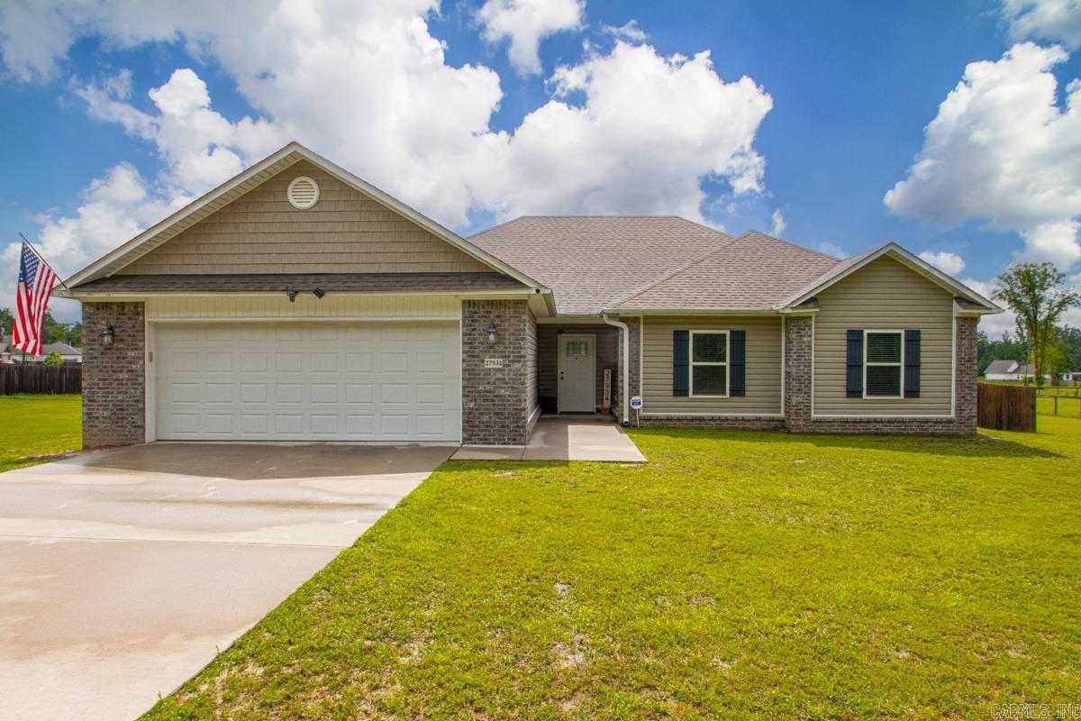 Discover this stunning Bauxite beauty featuring 3 spacious bedrooms, 2 full bathrooms, and a large open-concept living, dining, and kitchen area perfect for entertaining. The chef’s kitchen is equipped with granite countertops, a breakfast bar, stainless steel appliances, and a convenient lazy susan, while the expansive living room offers a cozy wood-burning fireplace. This split-bedroom floor plan ensures privacy, with large secondary bedrooms featuring walk-in closets and a massive primary suite that includes a soaking tub, separate shower, and two generous walk-in closets. Functional highlights include a dedicated laundry room and an oversized two-car garage, all situated on approximately 1.40 acres of land. The exterior boasts a large covered back porch for relaxing and a partially fenced backyard with a wood privacy fence, providing ample space to build a custom shop or pool. See Showing Remarks.