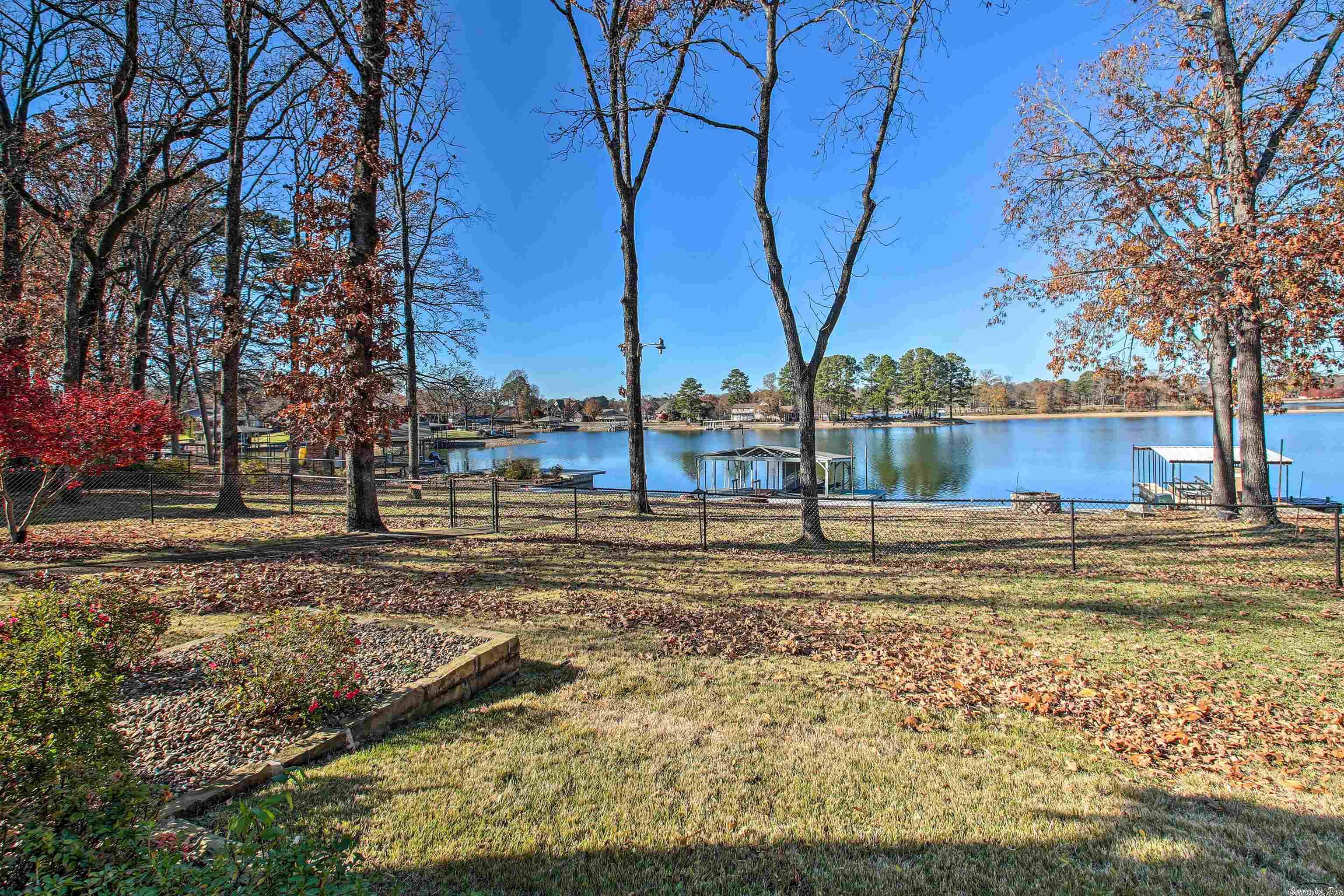 THE BEST OF LAKE LIVING with AMAZING VIEWS! Enjoy all that Lake Hamilton has to offer in this UPDATED 4 bedroom, 3.5 bath home right on the water's edge with hard to find FLAT lot. Views from every room. Selling completely furnished! New paint throughout, updated kitchen, new flooring, new hardware, new landscaping with sprinkler system, new washer/dryer, new grill, new furnishings inside & out, 2 stall boat dock with lift, 3 HVAC units and much more. In-law quarters/office area located off garage.