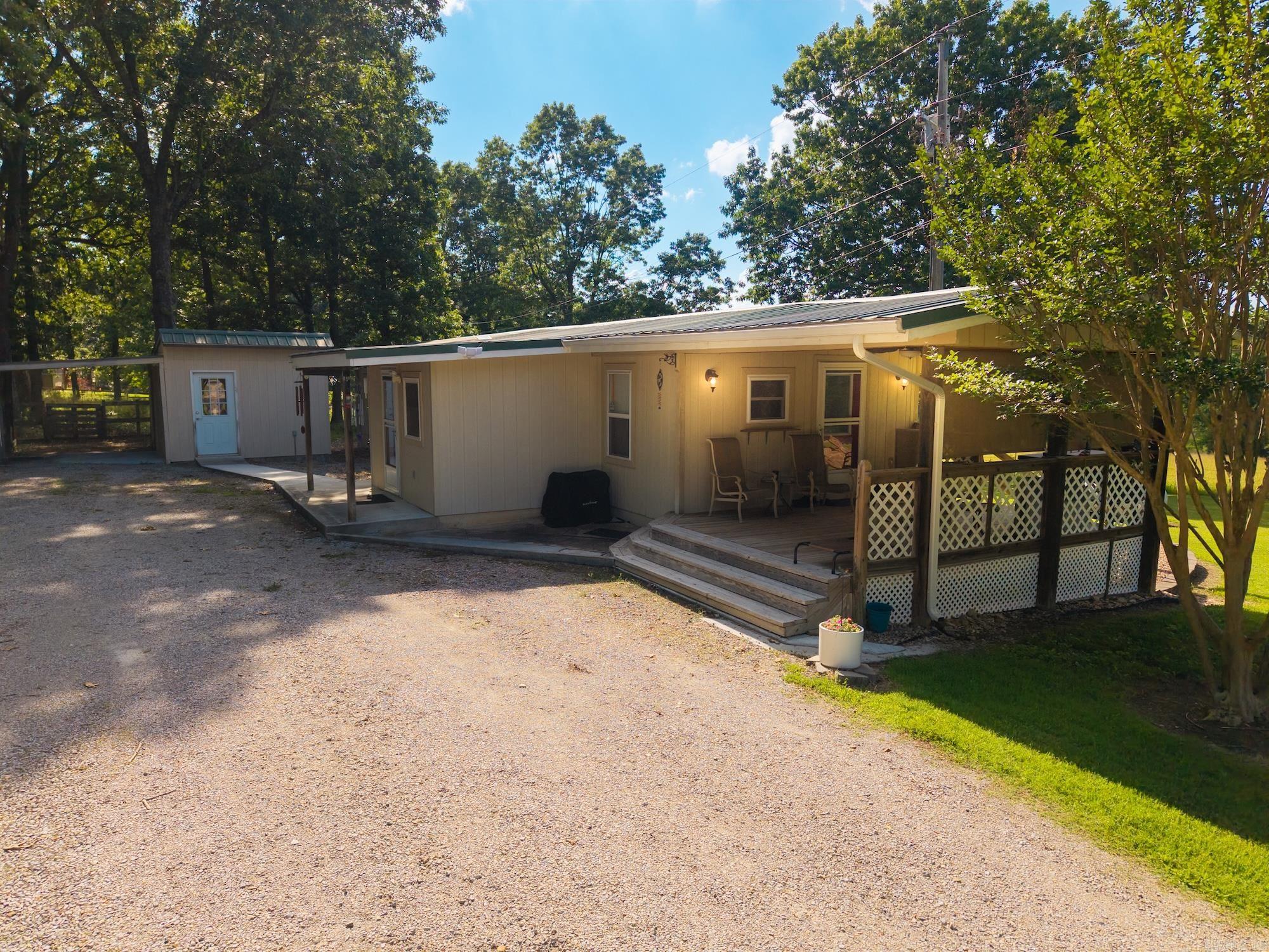 Enjoy peaceful country living while being just minutes from town. Situated on 1.6 idyllic acres, this meticulously maintained 2-bedroom, 1-bath mobile home is move-in ready and full of charm. Inside, you'll find attractive vinyl flooring, a beautifully updated kitchen featuring new cabinetry, and a practical mud room. Outside, the property provides ample space for hobbies, storage, and projects, and includes a she-shed.  Parking is a breeze with a 1-car carport featuring a lean-to, plus a detached 1-car garage with electricity. Whether you're looking for your first home, a peaceful retreat, or a property with room to enjoy the outdoors, this one is a must-see!