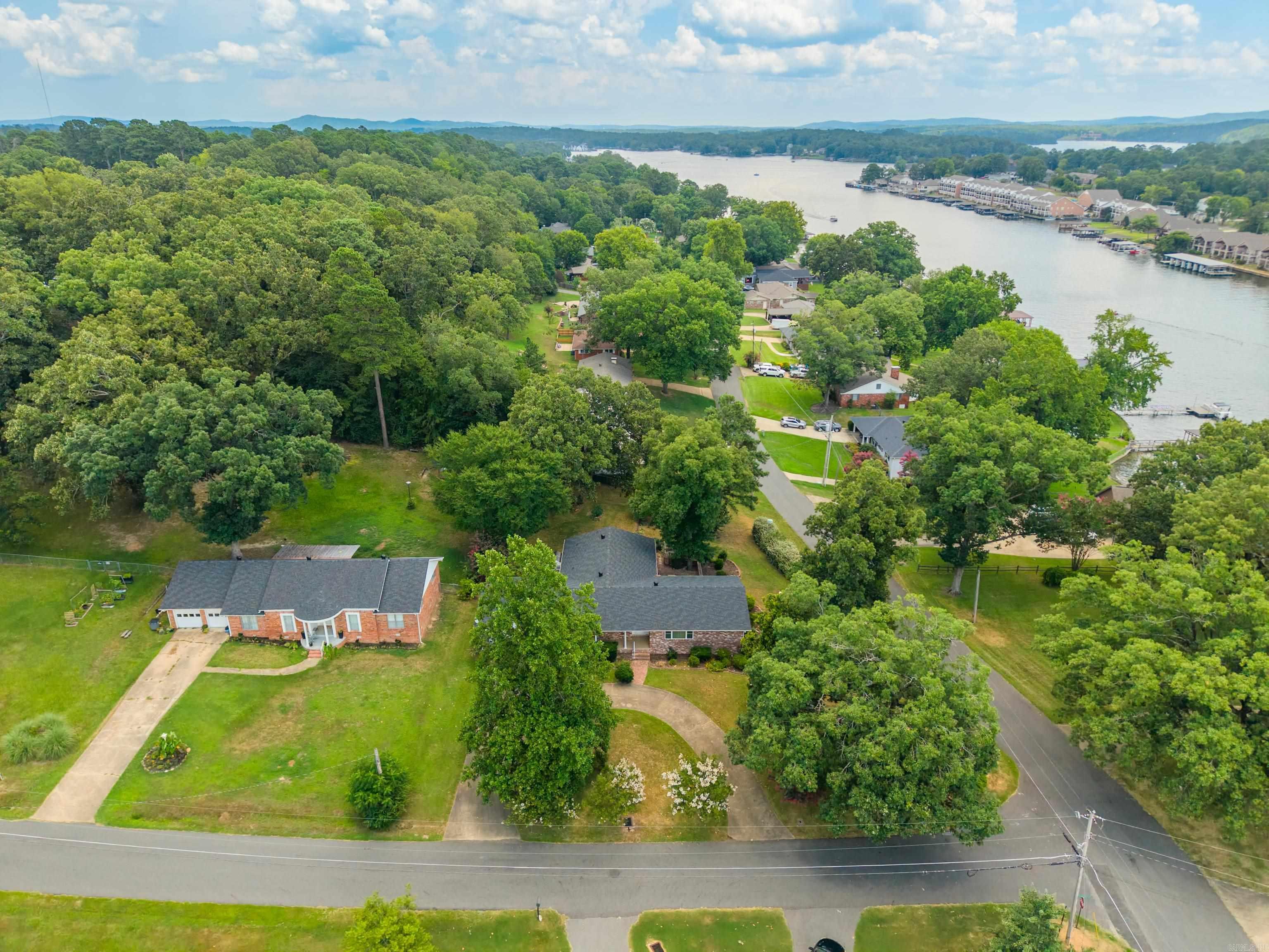 Excellent location in a well kept neighborhood. This 4/2 brick home with lakeview is within three minutes drive of a marina and launching ramp (pay to launch) Kitchen/dining combo as well as living/dining combo. Separate den with gas log fireplace. Granite countertops in kitchen & baths. Two pantries and double ovens. The grounds are adorned with shrubs. Chain link fenced backyard, greenhouse and storage building. Circle drive, newer architechural shingle roof. Heat and air unit 2024, hot water heater 2020. Washer, dryer and refrigerator convey. Two car garage with attic storage, one step up from garage into home. Needs topped off with your personal touches. No nightly rentals are allowed in this subdivision.  Zoned RN-1, subdivision plat and bill of assurance on file.