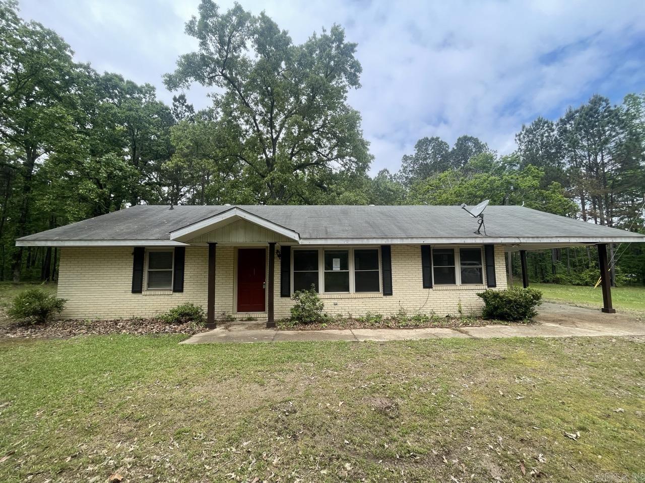 This charming brick ranch offers the quintessential Arkansas country lifestyle just minutes from the conveniences of Arkadelphia.  Step inside to a functional layout designed for comfort and ease. The heart of the home is a bright, inviting living room anchored by a large picture window that frames views of the expansive front acreage. The kitchen features a classic L-shaped design with abundant cabinetry, a gas cooktop, and a built-in wall oven, flowing seamlessly into a dedicated dining area. For added convenience, a spacious laundry and mudroom area is located just off the kitchen, providing a practical transition from the attached carport. The interior boasts three comfortable bedrooms and a full bath, with durable vinyl and tile flooring throughout for low-maintenance living. Outside, the property truly shines as an outdoor enthusiast’s or hobbyist’s dream. The 16x24 metal shop with a concrete slab floor provides the ideal workspace for projects, equipment storage, or a home studio.   HUD owned property, sold as-is. Agents see remarks.