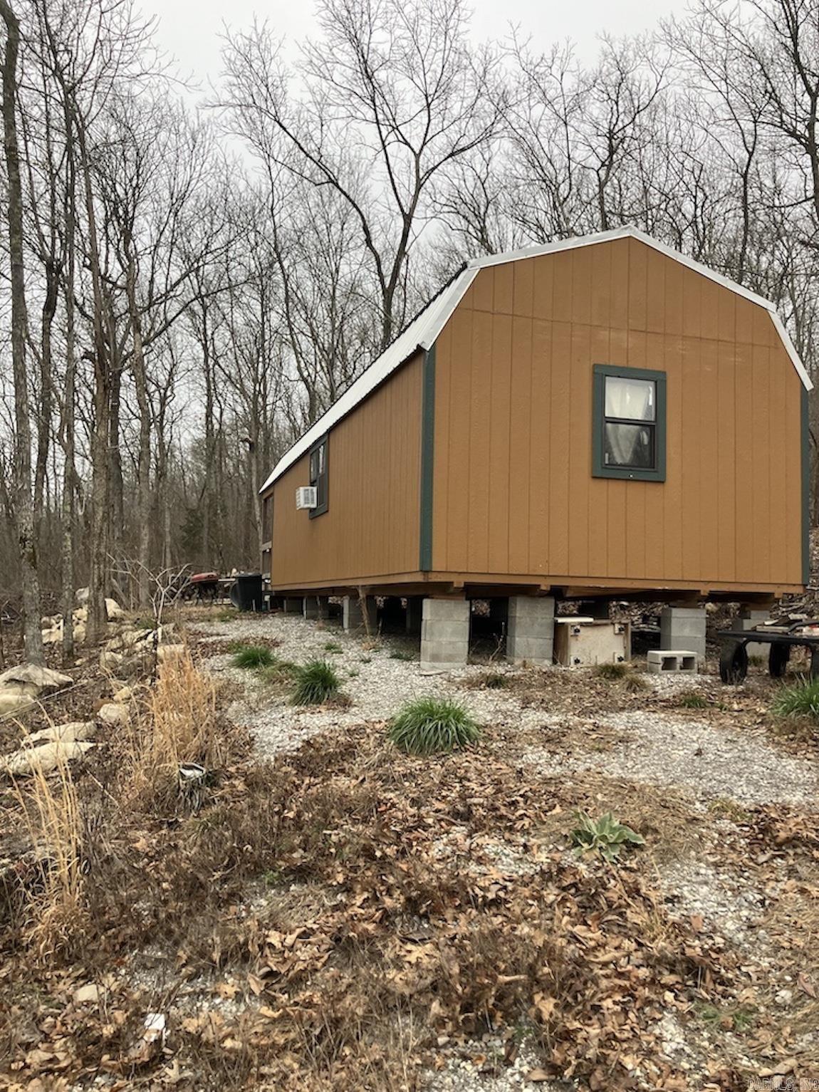 Located in the heart of the Ozark hill country, this property offers excellent road frontage, utilities, and a beautiful, crystal clear spring. With over 900 feet of county road frontage and access to city water and electric, the property is easy to reach and ready for future use. A driveway leads to a small off-grid cabin tucked within the acreage. The land features an established trail system that allows easy exploration by ATV or UTV. As you travel the property, you will find an impressive stand of mature hardwood timber, including white oak, northern red oak, post oak, walnut, ash, and hickory. A stunning freshwater spring emerges from the ground among the timber, creating a small waterfall as it flows through native stone. The terrain offers a mix of rolling hills, wooded flats, and scattered rock outcroppings with several potential building sites. Wildlife such as deer, turkey, and bear are common in the area, providing strong hunting opportunities. With no restrictions and close proximity to Mountain View, the Buffalo National River, White River, and Greers Ferry Lake, this property offers excellent potential for recreation, a private retreat, or future cabin development.