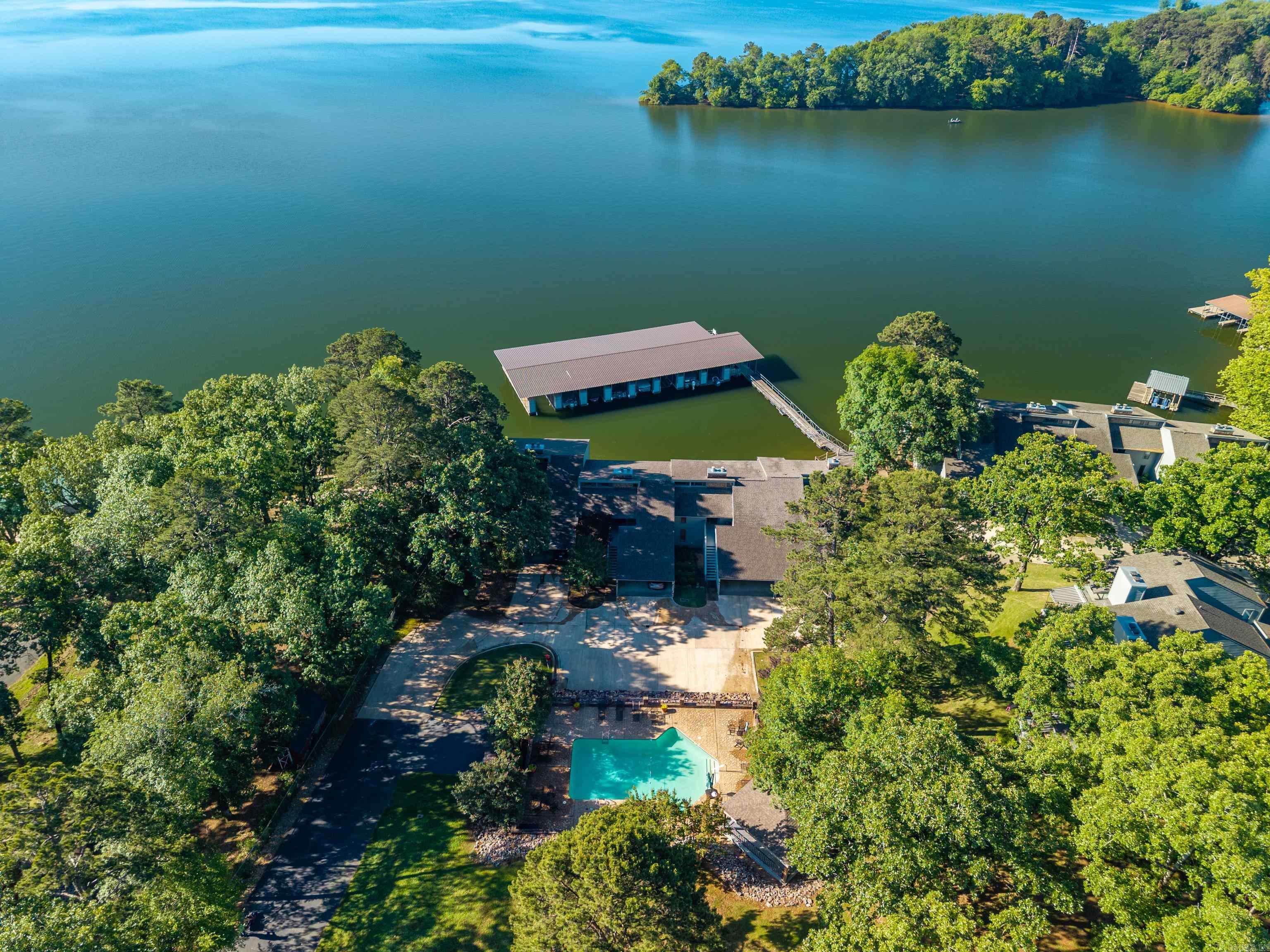 Discover the perfect blend of modern luxury and relaxed lakeside living in this beautifully renovated and fully furnished 2-bedroom, 2-bathcondominium on the shores of Lake Hamilton. Thoughtfully updated just a couple of years ago, this exceptional turnkey property offers high-end finishes, stunning architectural details, breathtaking lake views, and the convenience of being completely move-in ready in one of Hot Springs’ most desirable waterfront communities. Inside, soaring vaulted pine ceilings and expansive clerestory windows create a bright, open atmosphere filled with natural light. The spacious living room features a dramatic floor-to-ceiling stone fireplace, providing warmth and character while serving as the perfect gathering space after a day on the lake. The open-concept design flows seamlessly into the fully renovated kitchen, complete with updated appliances, sleek cabinetry, modern finishes, and ample workspace for entertaining family and guests. Both bathrooms were stylishly remodeled during the recent renovation and feature updated fixtures. Being offered fully furnished, this condo allows buyers to immediately begin enjoying lake life from day one!