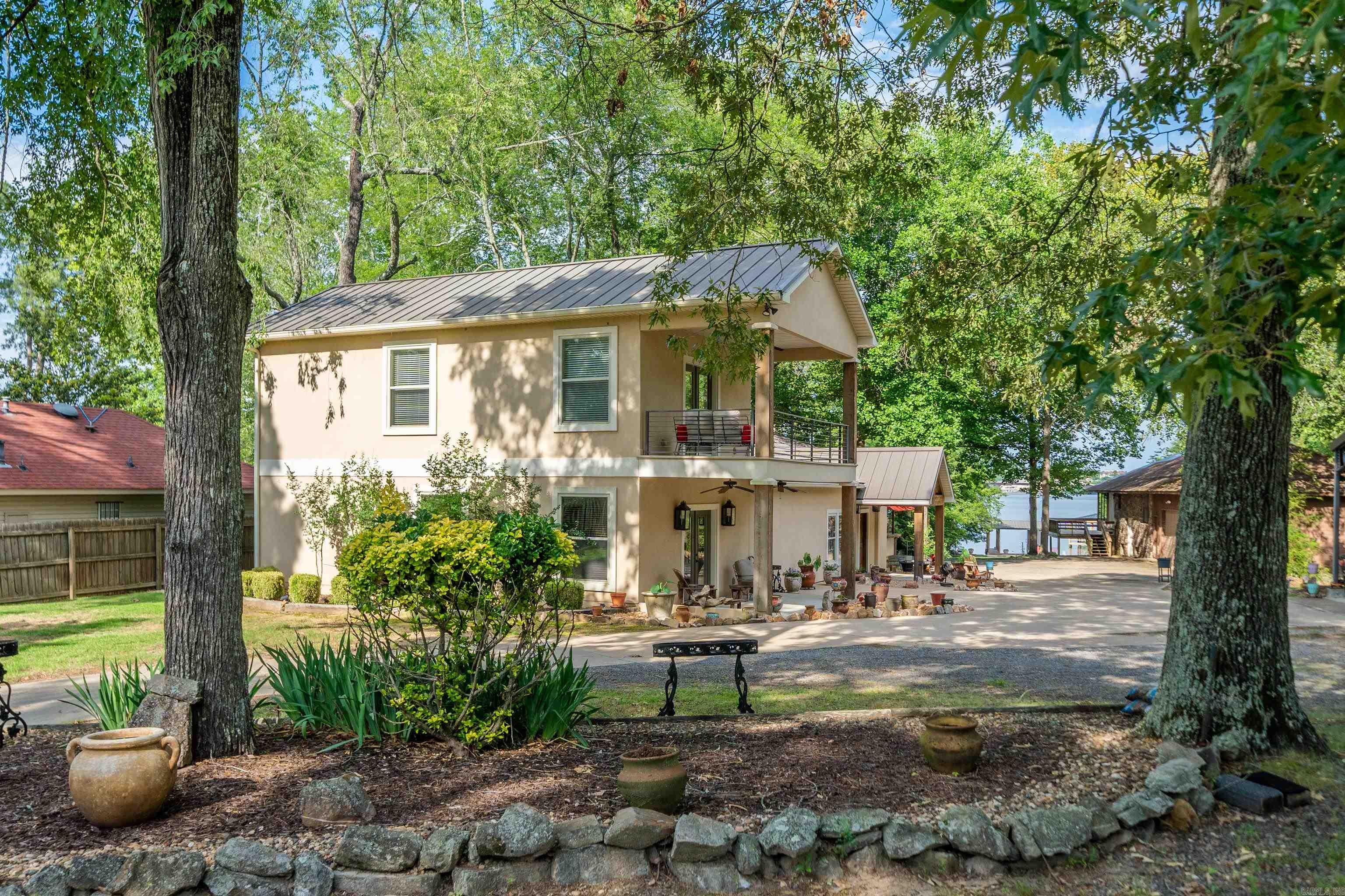Check out this unique opportunity to own a family compound with acreage on Lake Hamilton. A covered boat dock has additional concrete boardwalks & walkways to maximize your lake fun. The large yard leading to the lake has space for yard games or the addition of a pool.  110 Spurwink was remodeled to become a 4 bedroom/4 bathroom home w/ a flex room that would be perfect as a bunk room, gaming room, craft room, etc. There are 3 massive suites to choose from as your owner's suite. 2 of the bathrooms have massive luxury walk-in showers while the other 2 have oversized tubs with shower heads. The generator ensures you will stay comfortable during any power outages. And, the metal roof adds additional peace of mind. The 2 laundry rooms will  keep chores under control. And, all bedrooms have large walk-in closets to store all of those clean clothes. 112 Spurwink is a 4 bd/2 ba home that has been partially demoed to see its potential.  Both living areas are full of windows to bring lake views front & center. There is a 2 car garage attached -- plus, an extra tall 3-car carport for parking RVs, boats, etc. The expansive 1.44 acres allows for a garden or more housing. Come take a tour!