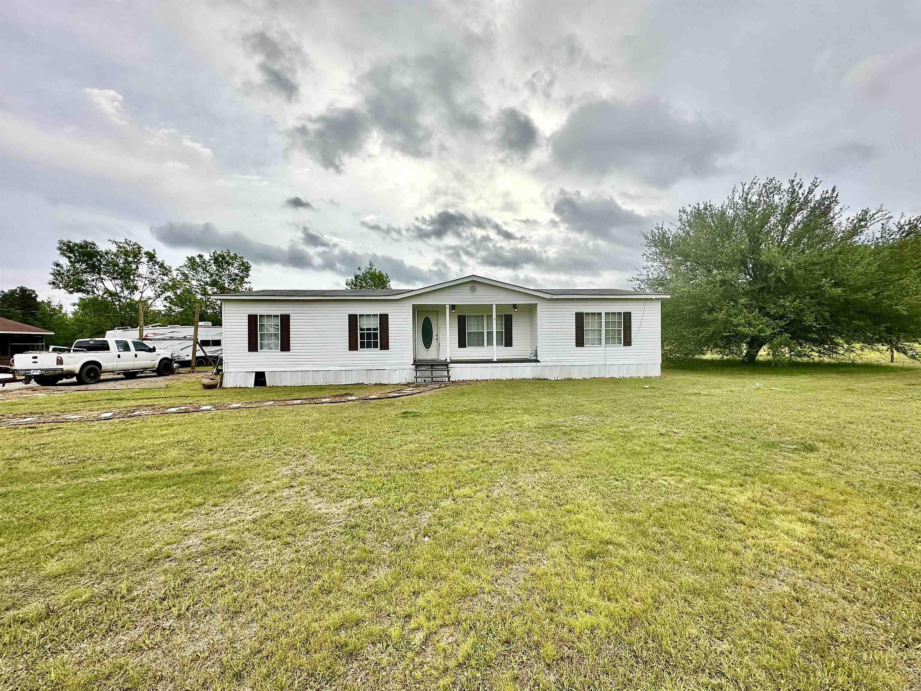 This 3 bedroom, 2 bathroom mobile home sits on 20.8 acres of stunning property. Home features a split floor plan with a spacious kitchen and dining space. Living room has a woodburning fireplace. Separate laundry room.  With ample pastureland, this property is well-suited for those interested in farming or raising livestock. The stocked pond provides a great opportunity for fishing and enjoying the outdoors. The additional exterior buildings offer plenty of storage space or could be converted into a barn for housing animals.  While the additional mobile home on the property is not currently considered to have any value, it could be renovated or used for extra storage space. Overall, this property offers a perfect opportunity for country living and enjoying the peaceful surroundings of rural life. Agents see remarks!