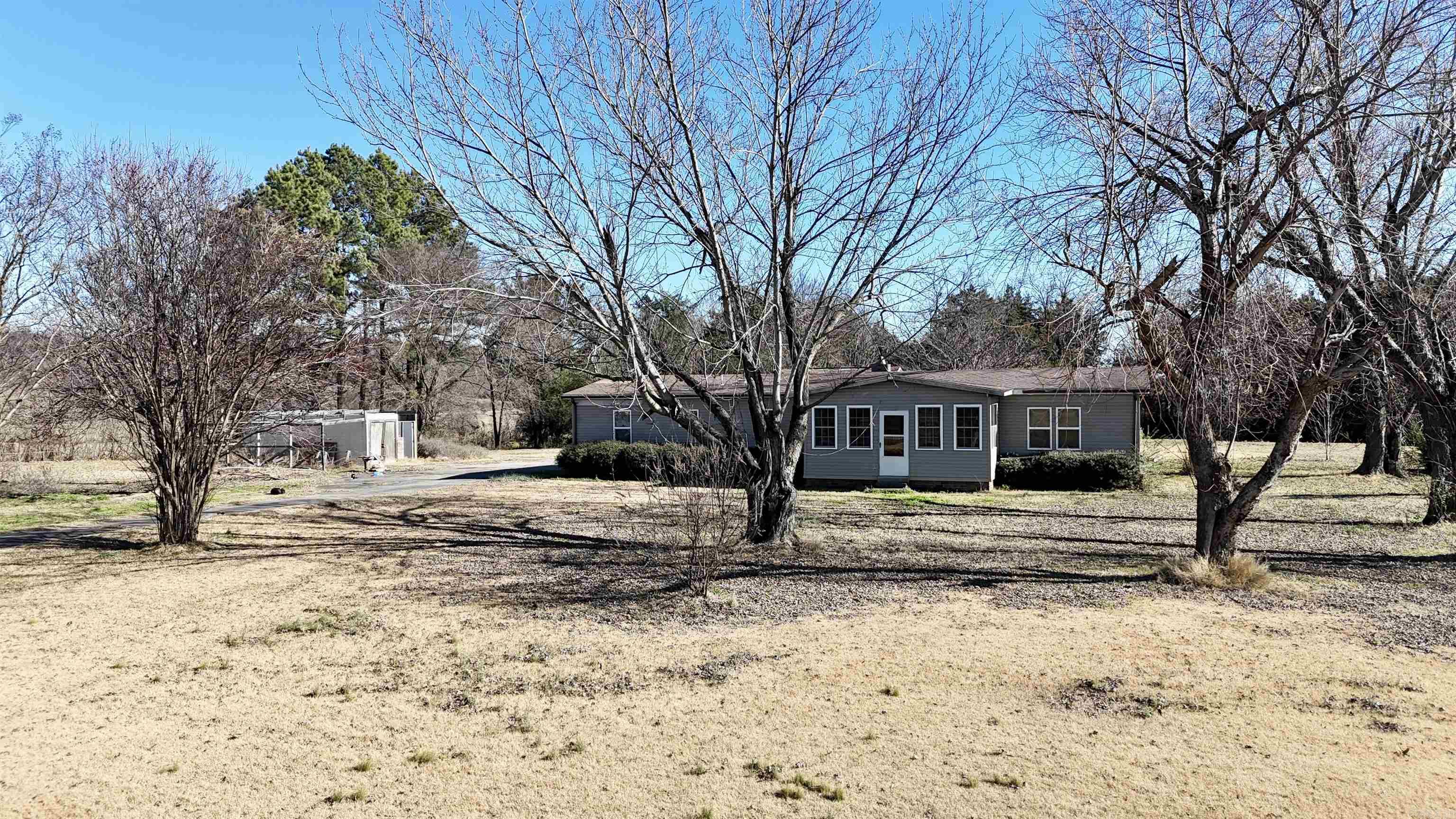 Charming property in Altus featuring a 3-bedroom, 2-bath manufactured home situated on approximately 2.48 acres. This gated and fully fenced setting offers privacy and room to roam. The interior is  complemented by two spacious primary walk-in closets. Enjoy peaceful mountain views and breathtaking sunsets from the enclosed front porch—perfect for relaxing year-round. A serene retreat with the space and scenery to match.