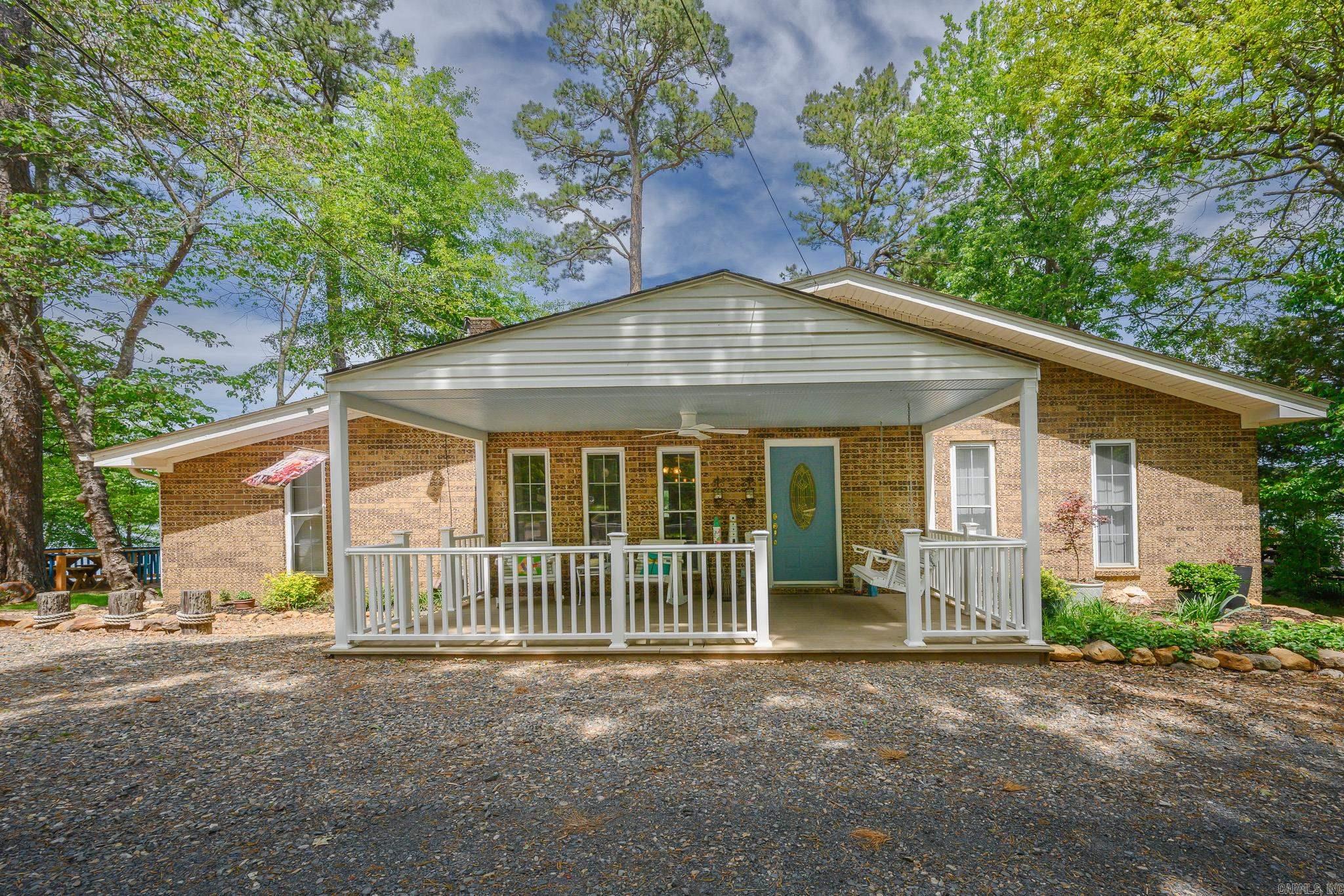 LAKE HOUSE WITH PRIVATE LAKE ACCESS, DOCK AND OUTDOOR LIVING! This move-in ready 3BR/2BA home offers the perfect blend of recreation, comfort, and scenic beauty with a center lake view overlooking Rich Mountain and future trail systems. Enjoy private lake access with a covered dock, new decking, updated walkway, lighting, and electric—perfect for fishing, kayaking, and boating. Outdoor living shines with a redesigned lakeview deck accessible from the sunroom and primary, a lakeside patio, fire pit with seating, and a new 10x20 front porch. Extras include a bocce ball court, walkways/areas for cornhole, fruit trees, and beautiful landscaping. Inside, the open-concept layout features a fully remodeled kitchen with a large granite island, custom cabinetry, pantry, reverse osmosis system, and high-end appliances. The sunroom offers year-round lake views with a new PTAC unit. Additional highlights include updated flooring, expanded guest bath, spacious primary with deck access, walk-in shower, and separate laundry. Oversized garage and workshop included. Lake life is calling!