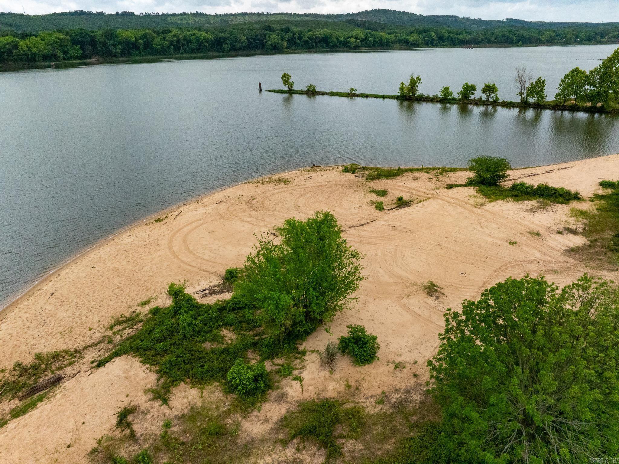 Sandy Beach in the Portland Bottoms delivers exceptional recreational value. Located just 20 miles from Conway and 15 miles from Morrilton, this property offers convenient access while maintaining a quiet, private atmosphere.  Outdoor enthusiasts will appreciate the outstanding deer hunting and excellent fishing opportunities along the Arkansas River. Positioned between dams, this stretch of river feels more like a lake, creating ideal conditions for anglers targeting catfish and other species.  One of the property's standout features is its expansive sandy beach, perfect for relaxing by the water, hosting family gatherings, or enjoying evenings around a bonfire with fishing poles set along the shoreline. Despite being located near I-40, the property feels secluded and peaceful, providing a true escape without sacrificing accessibility.   Whether you're looking for a hunting retreat, fishing getaway, weekend camping destination, or a recreational investment property, Sandy Beach offers remarkable outdoor opportunities in a manageable-sized tract.   Right at 20 miles from Conway, and 15 miles from Morrilton.  (Final price tbd by a new survey and price per acre.)