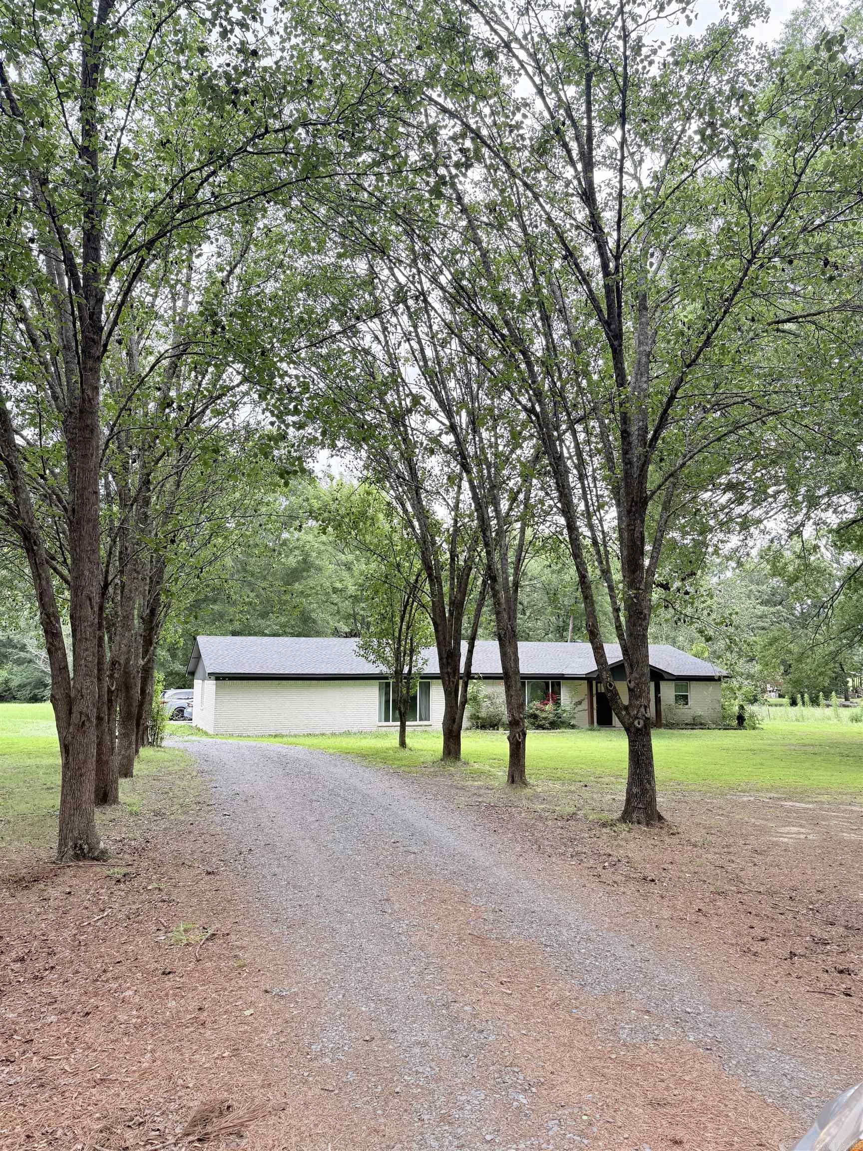 Completely remodeled down to the studs in 2021, this stunning home on 5 acres offers the perfect mix of modern updates and peaceful country living. Major items including the roof, HVAC, tankless water heaters, and windows are all approximately 5 years old. Inside, you’ll love the painted rock fireplace with gas logs and built-ins, LVP flooring throughout with tile in wet areas, and no carpet anywhere. The kitchen features granite countertops, a gas range, and an oversized single-basin sink. The extra-large primary suite includes a huge walk-in closet with dresser island, plus a spa-like bath with a rain shower and soaking tub. Additional features include a spacious mud room and a beautiful covered back porch with wood slat ceiling. If you’ve been looking for acreage with modern finishes and move-in-ready updates, this is it!