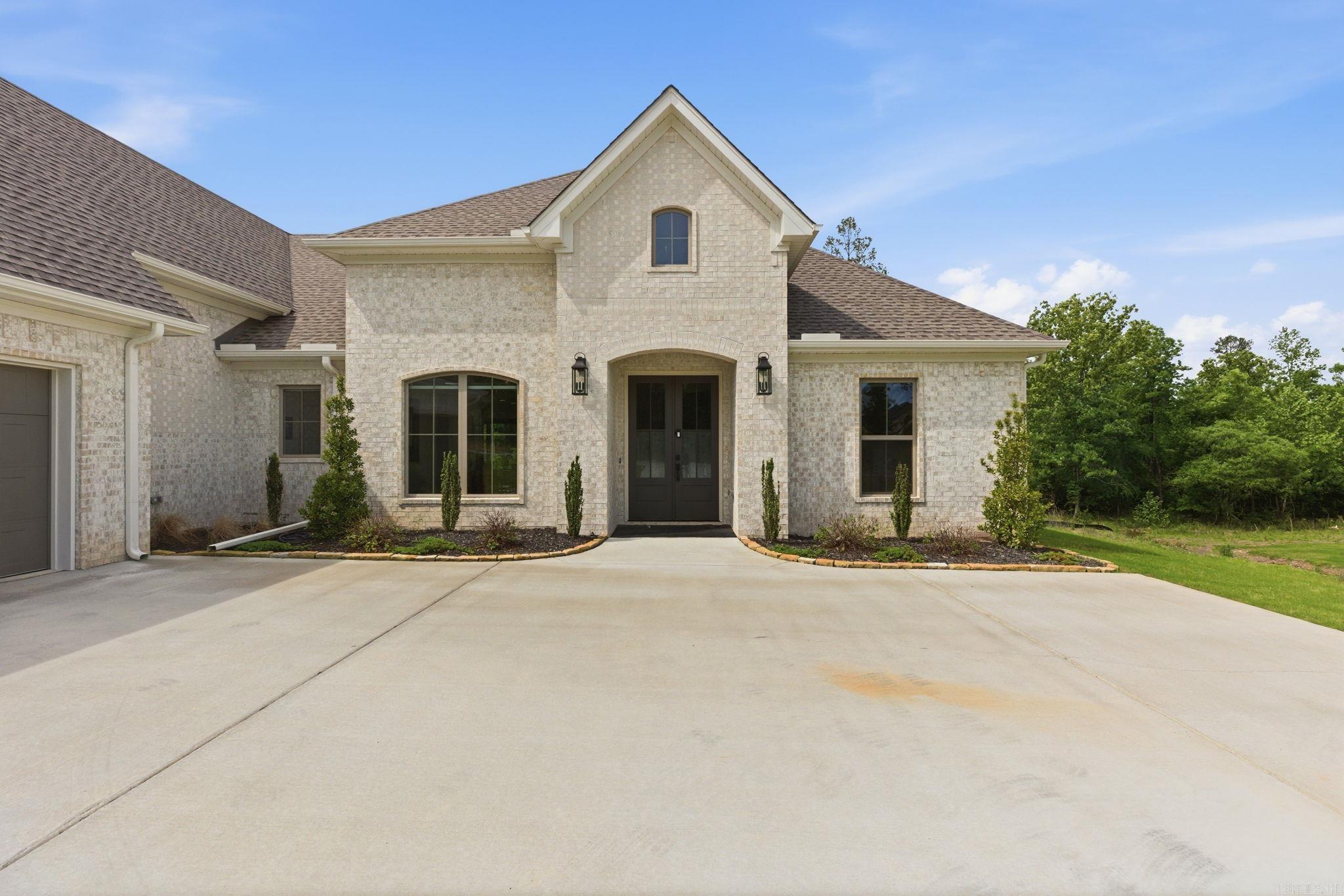 Built in 2025, this beautifully designed 4-bedroom, 2.5-bath home offers 2,581 sq ft of living space on a rare 1.32-acre lot in the highly desirable Charleston Place subdivision. The open-concept layout features a spacious living area with corner fireplace flowing into a chef-inspired kitchen with oversized island, quartz countertops, custom cabinetry, and premium appliances. A separate dining room provides additional space for entertaining. The private primary suite includes a spa-style bath with soaking tub, walk-in shower, and expansive closet space. Energy-efficient construction with Low-E windows and upscale finishes throughout. Situated against a peaceful wooded backdrop with frequent deer sightings and stunning sunset views, this property offers exceptional privacy while remaining conveniently close to Benton and Bryant amenities. Executive-style home ideal for relocation buyers seeking space, tranquility, and modern construction.
