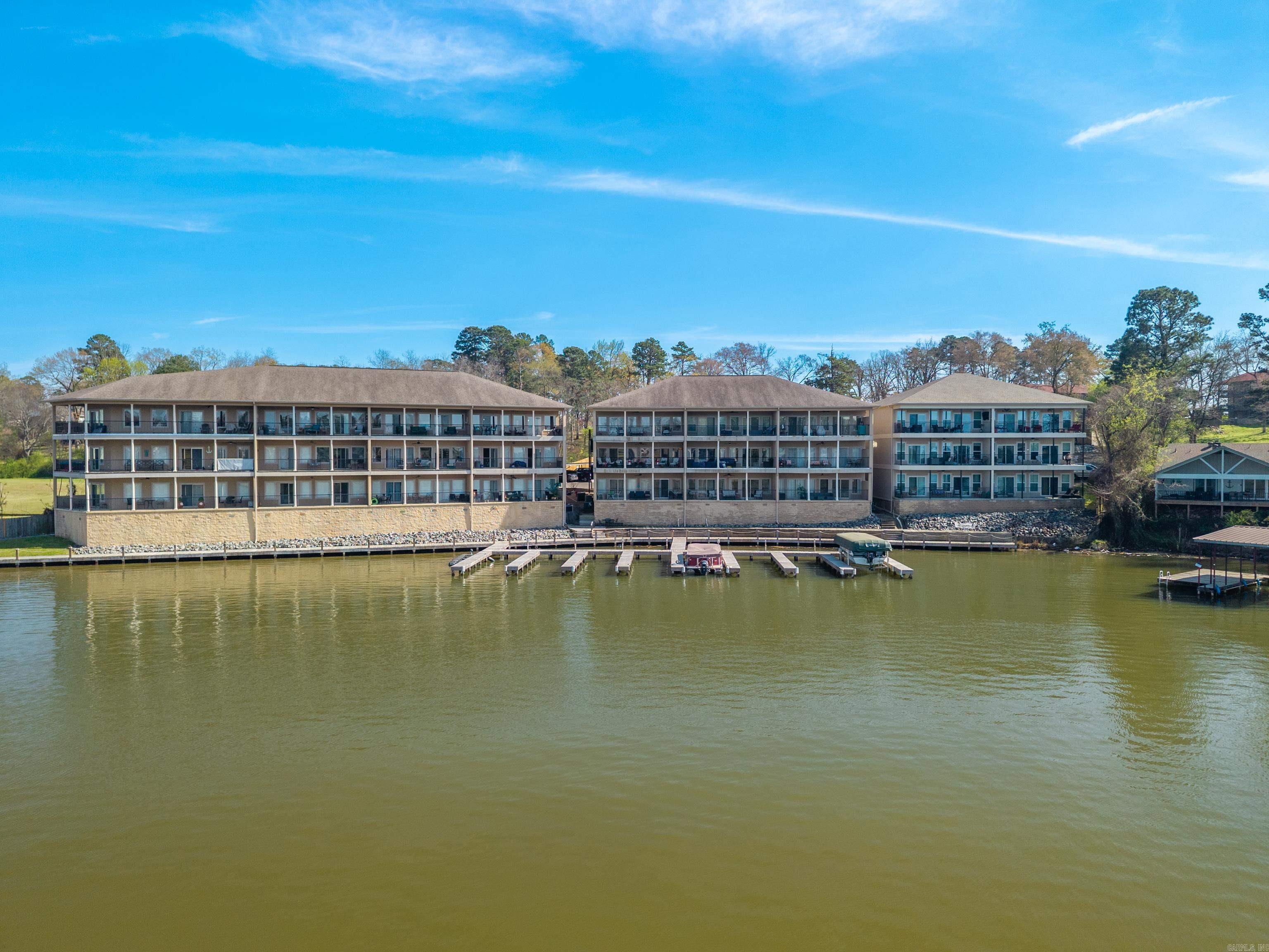 Top-floor lakefront living with unbeatable views! This beautifully maintained 2-bedroom, 2-bath condo on Lake Hamilton offers soaring vaulted ceilings and breathtaking 180-degree views up and down the main channel. Whether you’re enjoying your morning coffee or unwinding at sunset, the expansive lake views take center stage from this elevated unit. Currently operating as a successful short-term rental, this property is being sold fully furnished—making it completely turnkey and ready for immediate use as an investment, weekend getaway, or full-time residence. The open-concept layout provides a spacious and inviting atmosphere, perfect for entertaining or relaxing after a day on the water. Convenience meets comfort with elevator access in the complex, making this top-floor unit easily accessible. Don’t miss this rare opportunity to own a move-in-ready lakefront condo with incredible views and income potential on Lake Hamilton!