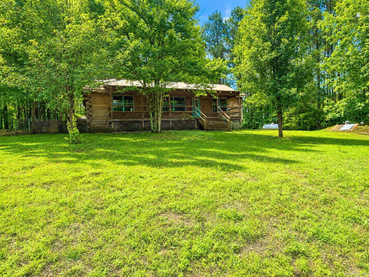 Escape to peaceful country living with this charming and secluded 2-bedroom, 2-bath log cabin home nestled on approximately 4 beautiful acres complete with a 40x8 covered porch overlooking the pond. Located outside city limits, this property offers the perfect blend of privacy and convenience with shopping, dining, and everyday amenities just 25 minutes away.  Enjoy easy access to multiple nearby lakes, making it ideal for outdoor enthusiasts, fishing, boating, or simply relaxing in nature. Whether you’re looking for a full-time residence, weekend retreat, or investment opportunity, this property is ready for new owners to make it their own. SOLD AS IS.