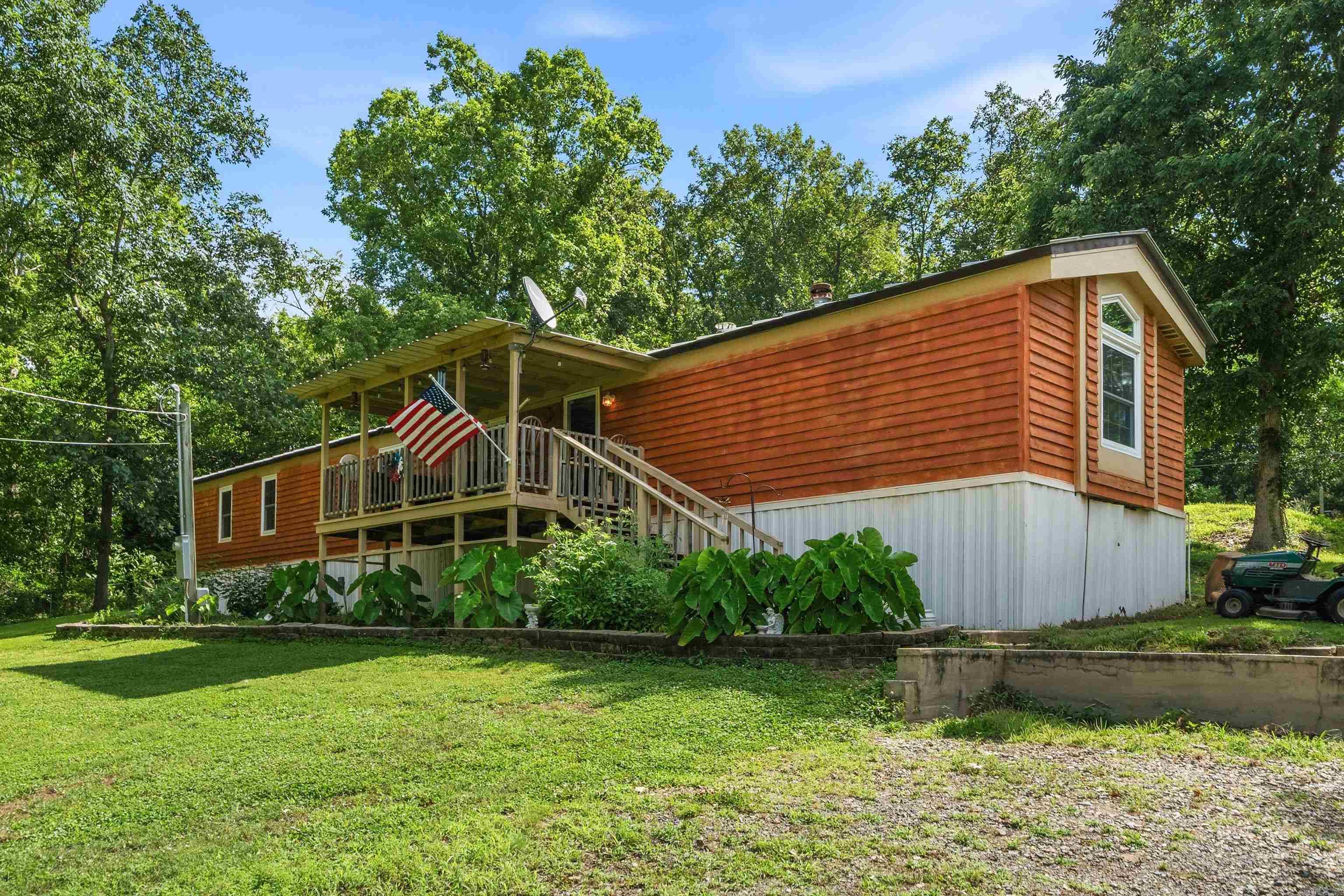 A peaceful country retreat nestled on approximately 1.9 acres with a nice view of the lake. This 4-bedroom, 2-bath home offers comfortable living space with many updates. Heat/air, hot water heater, refrigerator, range, and windows are appx 3 years old. Dishwasher is a month old. Solid oak cabinets in the kitchen with a breakfast bar. Exterior has metal roof and Cedar siding is appx 2 years old. Enjoy the tranquility of country living while still being just a short drive from Hot Springs and all its shopping, dining, entertainment, and outdoor recreation. Access to a private boat ramp across the street. Minutes to Blakely Dam or Lake Ouachita State Park. The spacious property provides plenty of room for gardening, outdoor activities, animals, or simply relaxing and taking in nature's scenery. Whether you're looking for a primary residence, a weekend getaway, or an investment opportunity, this property offers exceptional value with acreage, privacy, and beautiful views. Also, a storage building and a building pad for another home or shop. Don't miss out! Call and schedule your tour today!