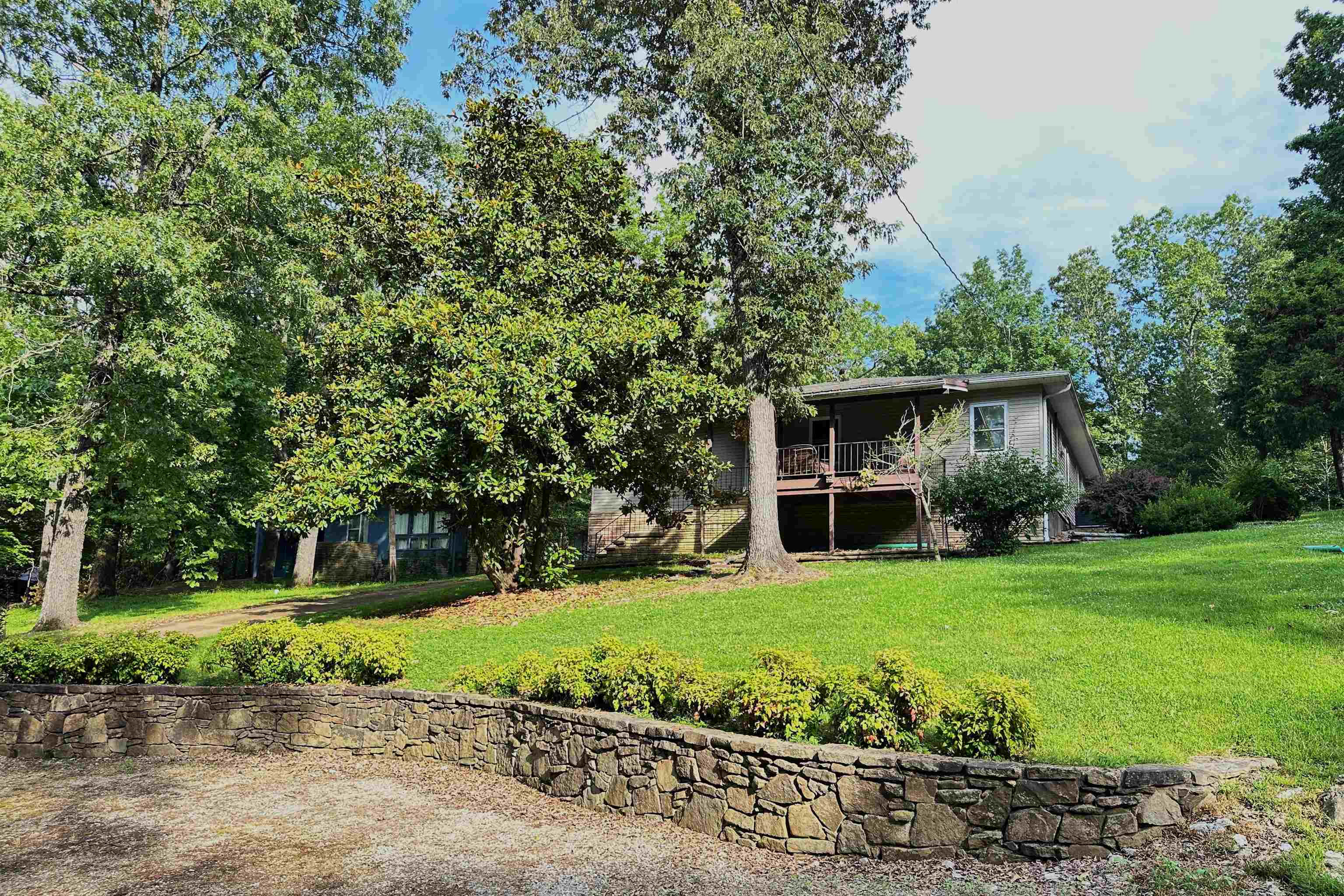 Charming, move in ready, and clean as a whistle! This well cared 2 bed/2.5 bath on 3/4 of an acre home is a retreat inside and out.  Large windows throughout allow beautiful views of nature and natural light all year round. Our beautiful Cherokee Village offers 7 lakes, 2 golf courses, hiking trails, and much more tucked in the Ozarks. This home is perfectly situated to enjoy all of these, but perfectly appointed to enjoy staying home, too! Features include a lovely kitchen with lots of storage and counter space including a breakfast bar and is open to the dining and living rooms. The living room has a picture window over looking the tree tops and a beautiful fireplace and dedicated office area. Both bedrooms have private baths. For those times when you want to retreat from it all...look no further than the primary suite and ensuite with such great space you may just spend the day there!  Don't forget to ooh and ahh over the primary closet, too!  With 1911 square feet inside, porches in front and back, 3/4 acre yard to love you'll have plenty of elbow room here. Did you see all of the extra parking and even the RV parking?  Don't wait!