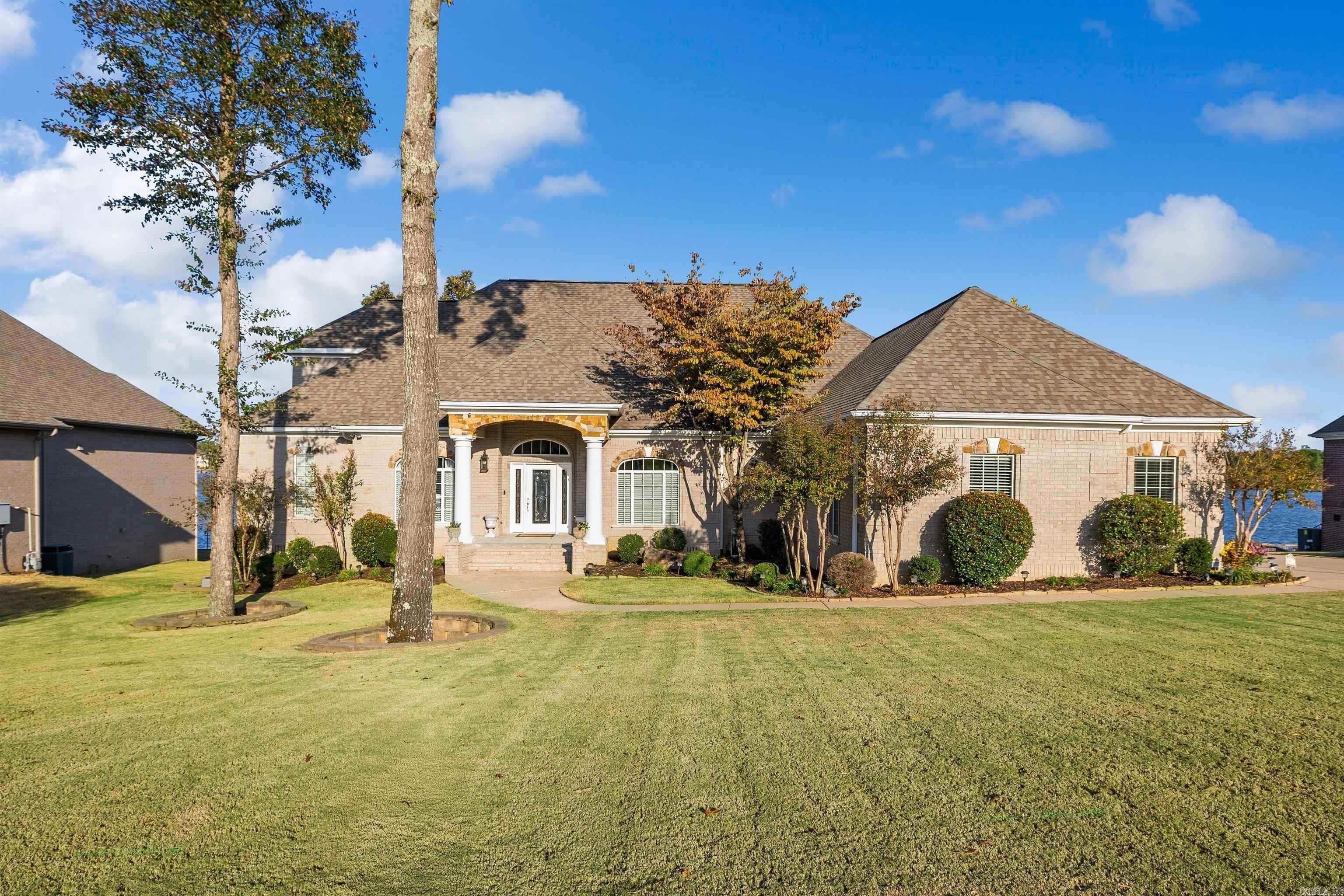 BREATHTAKING LAKEFRONT LIVING ON HURRICANE LAKE! From the moment you step inside, the sweeping water views visible from nearly every main room will leave you speechless. The gourmet kitchen is built for serious cooking, featuring a gas range, double ovens, and rich cherry wood cabinetry that flows seamlessly into a warm hearth room anchored by a gas fireplace. Retreat to the main-level primary suite, complete with its own fireplace, a beautifully appointed bath with double vanity, and an oversized walk-in closet. A second primary suite on the main floor provides flexible living for guests or multigenerational needs. Entertain in the formal living and dining rooms, unwind in one of two sunrooms perfectly positioned to soak in the lake views and wildlife, or make use of the impressive bonus spaces-including a theater room, game room, craft room, and a private office with its own kitchenette. A workshop tucked beneath the home adds even more versatility. Step outside onto the expansive deck overlooking a flat, fully fenced backyard complete with a retaining wall, wrought iron fencing, and your own private boat slip. Opportunities like this on Hurricane Lake don't come around often!