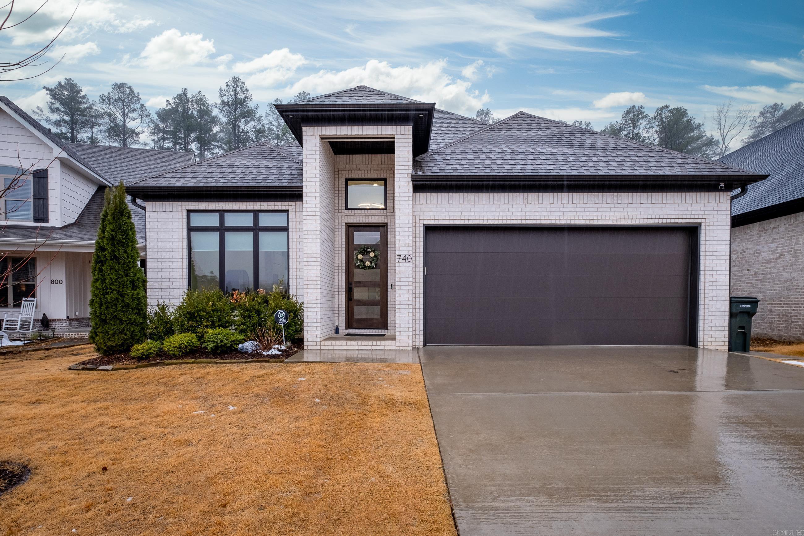 Beautiful modern like-new construction in Wildwood Place! Tall ceilings invite you into the open flow of the formal dining room into the kitchen and living space. Luxurious quartz kitchen counters with stainless appliances, sleek white cabinets, gas range, pantry, and breakfast bar. Great room features gas log fireplace, wood flooring overlooking the outdoor covered veranda. Primary bedroom suite on main level has tiled walk-in shower, double vanities and massive walk-in closet. Also on main level is powder room, laundry room and a guest bedroom suite with a walk-in closet and an en-suite bathroom. Upstairs are two more bedrooms and full bath, plus walk-out floored attic space for easy store. The covered outdoor patio has wood-burning fireplace and looks out onto private, fully fenced level yard with a view of wooded greenspace. Front and back sprinkler systems, tankless water heater and two-car garage. Home is completely wired with Cat5 ethernet, with dedicated ethernet ports in each bedroom, living room, TV surface and outdoor TV space. Refrigerator, Fridge, security cameras (doorbell, indoor/outdoor) all convey. This is a gem!