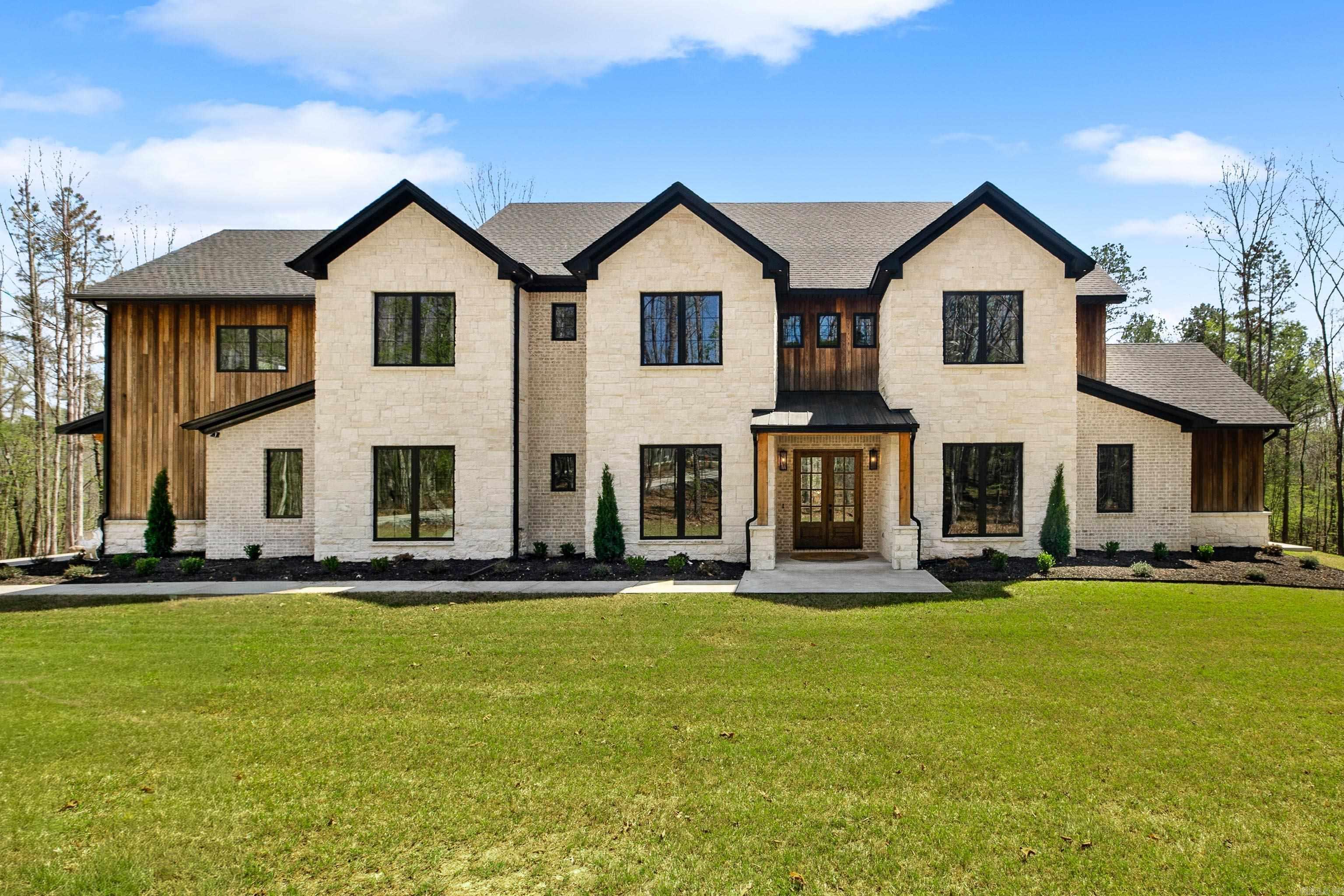 STUNNING PRIVATE ESTATE IN WILLIAMS CREEK NESTLED ON ALMOST 4 ACRES IN CUL-DE-SAC! This exceptional home features a luxury kitchen with a Sub-Zero refrigerator, Thermador 8-burner range with double ovens, dual Thermador dishwashers, wine bar with fridge and ice maker, and an expansive Butler’s pantry. The kitchen opens to a breathtaking two-story living room with a floor-to-ceiling stone fireplace and expansive windows. The primary suite offers dual closets, private covered porch, and a spa-like bathroom with dual vanity, stunning shower, and free standing tub. Additional spaces include an office, formal dining room, bonus room with kitchenette, and a massive laundry room with cubbies and pet washing station. Enjoy outdoor living on the covered patio featuring cathedral ceiling, fireplace, and full outdoor kitchen. Extras include surround sound throughout, a fully irrigated lawn with raised play area, and a sceurity system with hardwired cameras. The steel 30x50 insulated shop with RV-size doors is perfect for the outdoor enthusiast! Only minutes from I-30, Benton, and Hot Springs!