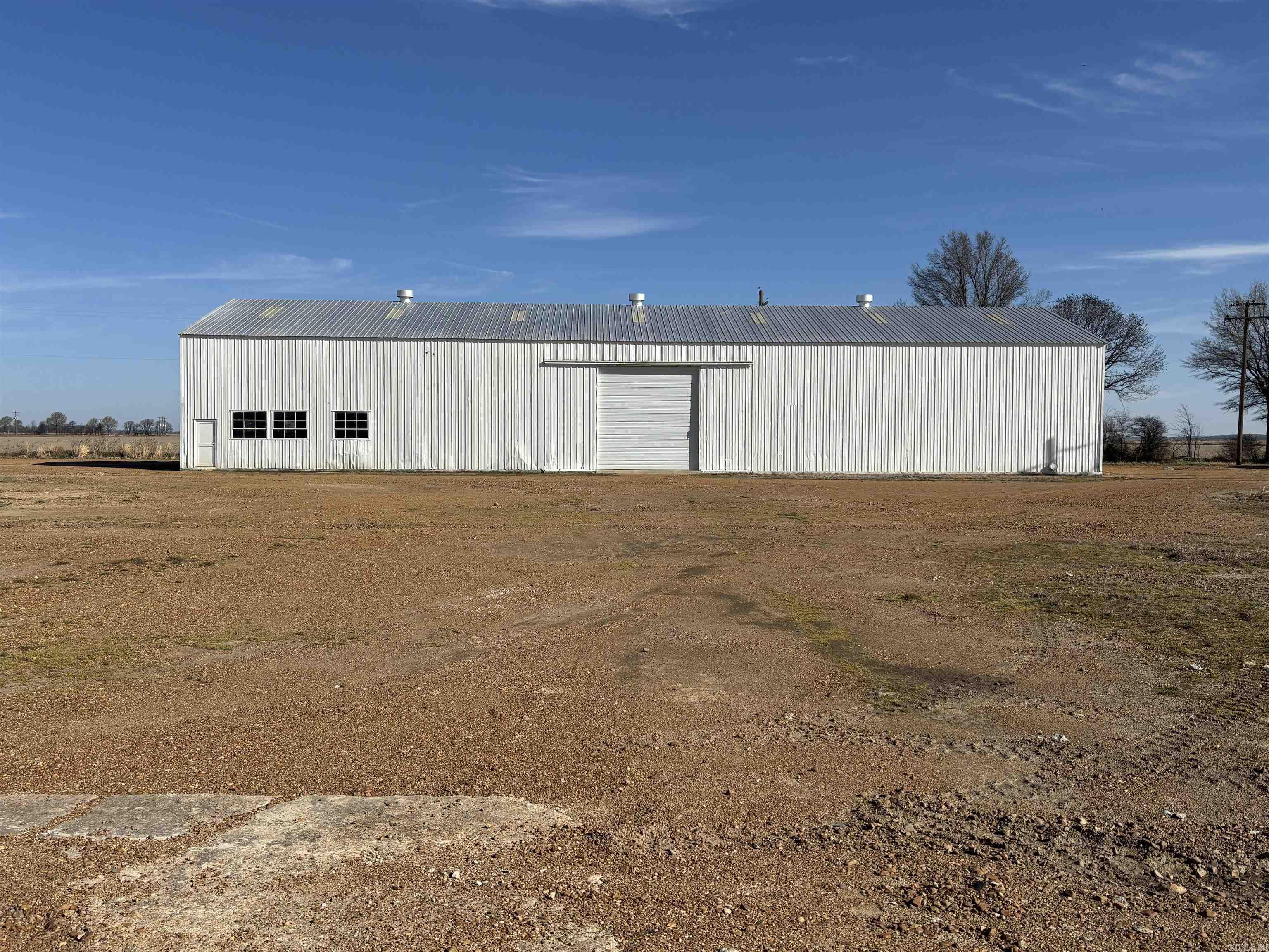 1 Farm Shop with parts storage bins and 3 story office/ inventory/ workshop bunkroom 70feet by 70 Feet 35 feet tall 2 overhead doors (25 feet tall) bathroom, cinder block walls, and metal framed building.  Full electric LED lighting,150-psig compressor, one welding plug, 110 volt plugs, overhead crane with junction box to place a 2 ton hoist if needed. Fully code compliant.  Electric outlets can be added to meet the lessee's needs. 1 Storage/manufacturing Shed 122 feet by 160 feet concrete flooring industrial strength load bearing floors throughout. One overhead door. No electrical power at this time. 1 Storage/manufacturing Shed 50 feet by 140 feet dual overhead doors with seperate storage or office space.  Full electric LED Lighting, one welding plug, and 110 volt plugs.  Fully code compliant. electrical outlets can be added to meet the lessee's needs. 1 Wooden storage barn/shed 50 feet by 54 feet with sheet metal roof and with two lean to sides that have concrete floors.  No electric power at this time. 1 brick veneer home/ office  2460 square feet 2 bath  with gravel driveway and carport Move in Ready.  Flat terrain with plenty of parking and additional building area if needed
