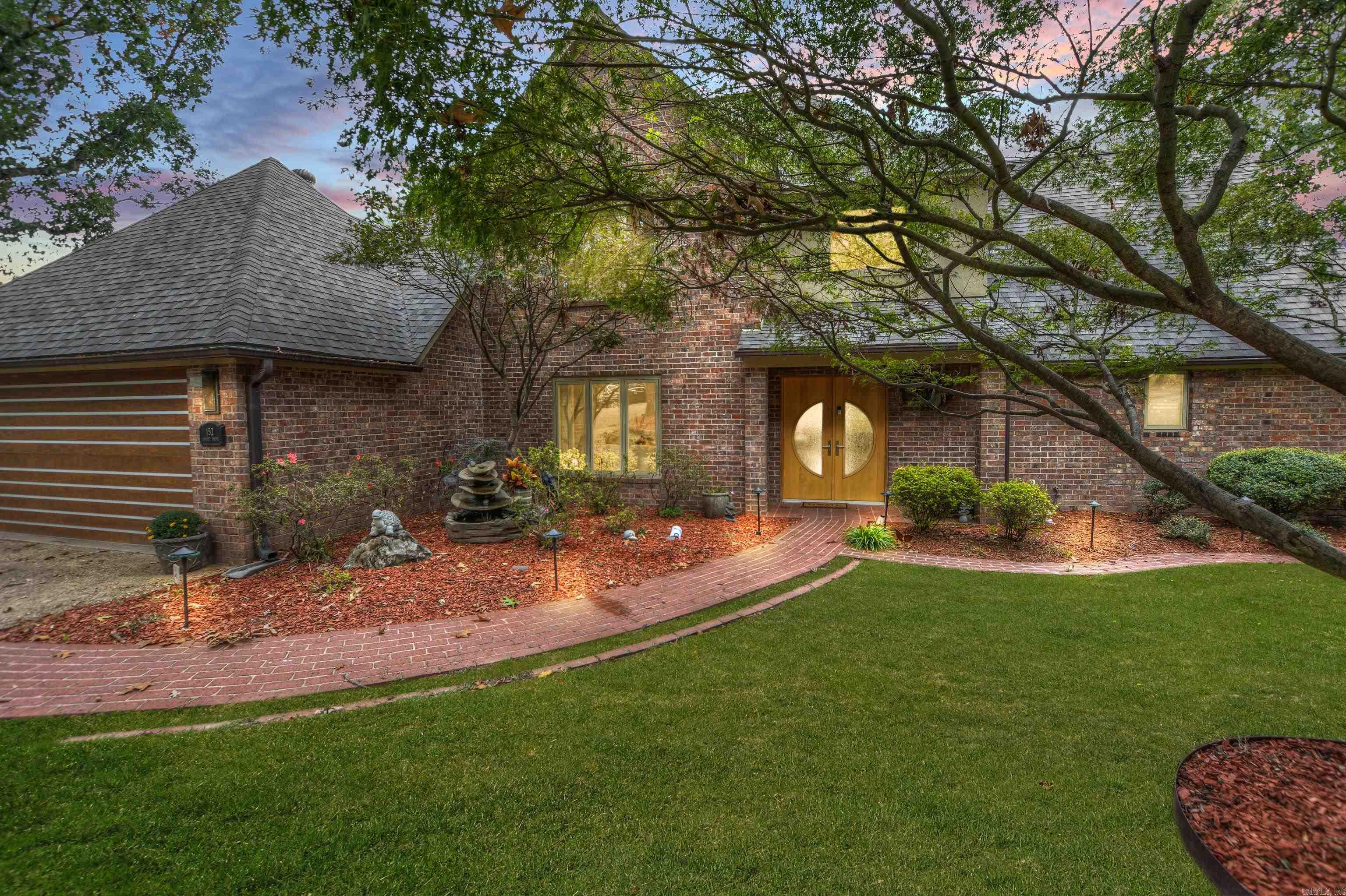 Indulge in the epitome of luxury living with this exquisite 4-bed, 3.5-bath home, spanning 3,000 sq ft. Built in 1992 and meticulously remodeled in 2016, this residence is a masterpiece of contemporary design and functionality. Nestled in the sought-after Driftwood luxury neighborhood, it embodies refined living.  Upon entry, be captivated by the grand foyer featuring a breathtaking crystal chandelier. The heart of the home is its expansive outdoor living space, an entertainer's dream with a full outdoor kitchen, wood-fired pizza oven, and an outdoor TV. Enjoy year-round comfort with built-in ceiling heaters and abundant natural light from sun tunnels.  Immerse yourself in a symphony of sound with stereo surround sound inside and out. Relax by the Koi pond in the fenced backyard or unwind in the private patio hot tub, easily accessible from the master bedroom.  Boating enthusiasts will appreciate the single-stall covered boat dock with a hydraulic lift, complemented by walls of glass offering stunning views of Lake Hamilton.  Inside, discover first-class features, including a formal dining area with a full-size wine refrigerator. The chef's kitchen boasts double ovens, a gas