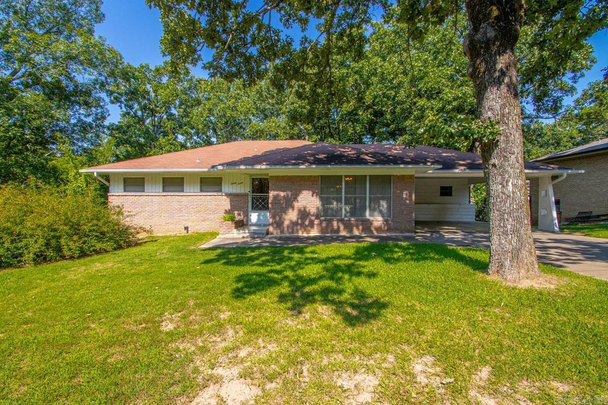 Bring your vision and discover all the possibilities this spacious brick home has to offer! With approximately 2,850 square feet, this well-built home offers room to grow! 3 bedrooms and 2 bathrooms are on the main level, including a primary suite with its own bath. The hall bathroom shows off charming mid-century modern tile work and period details. Beautiful original hardwood floors throughout the main level showcase the quality craftsmanship and timeless character of this home's construction. The walk-out lower level offers flexibility with a convenient half bath and space that's perfect for a second living area, game room, home office, hobby room, workshop, or future guest quarters. You'll also appreciate the abundant storage found throughout the home. The versatile floor plan is ideal for a growing family or multi-generational living. This property is situated on two generously sized lots and provides exceptional privacy and plenty of outdoor space to relax and entertain.  Whether you're looking to retain its original character or create your own vision, this quality-built home offers the space, layout, and setting to make it truly special. Agents see remarks.